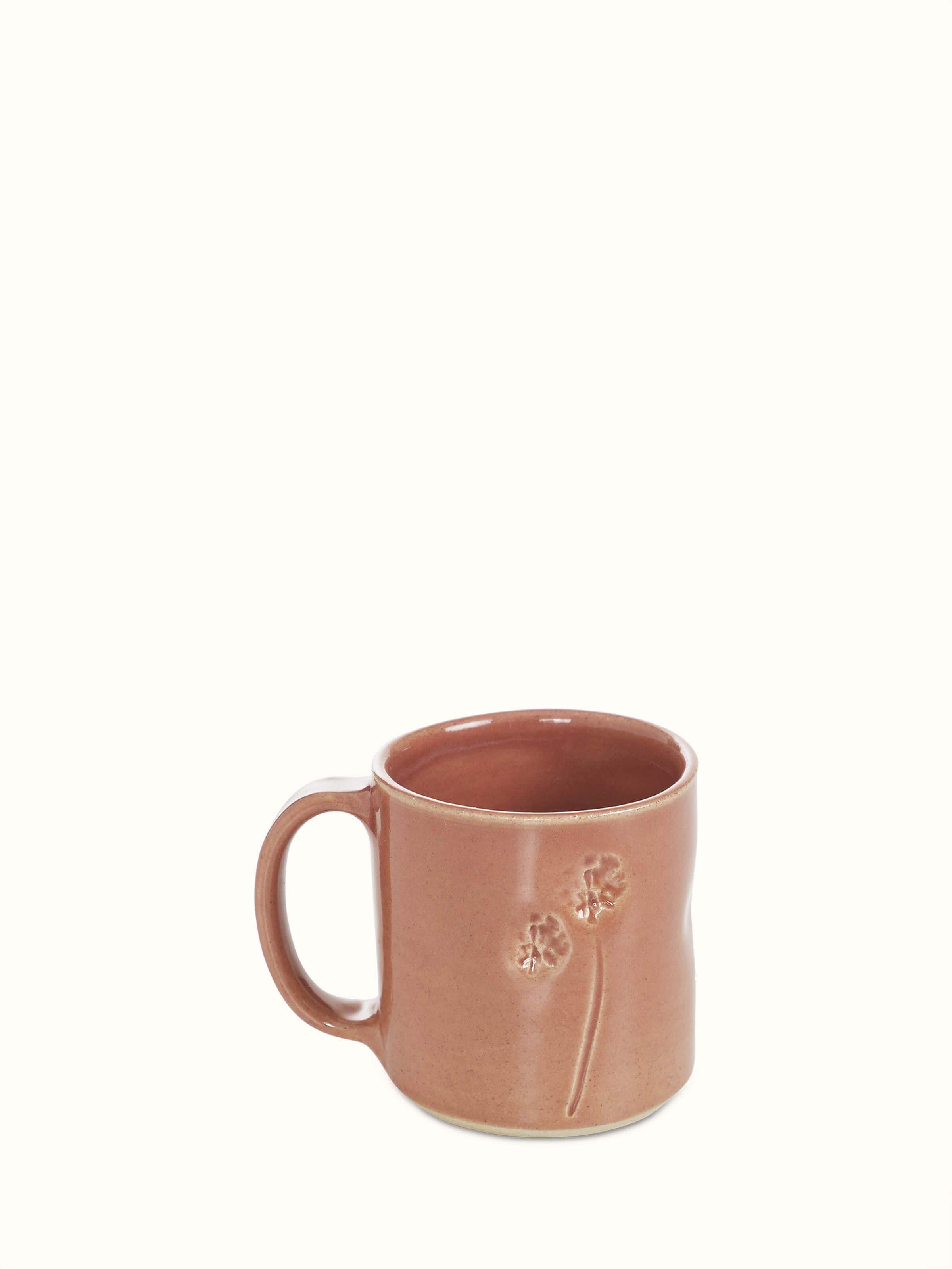 Front view of Studio pottery ceramic coffee mug in pink showcasing its elegant glaze and curved handle.