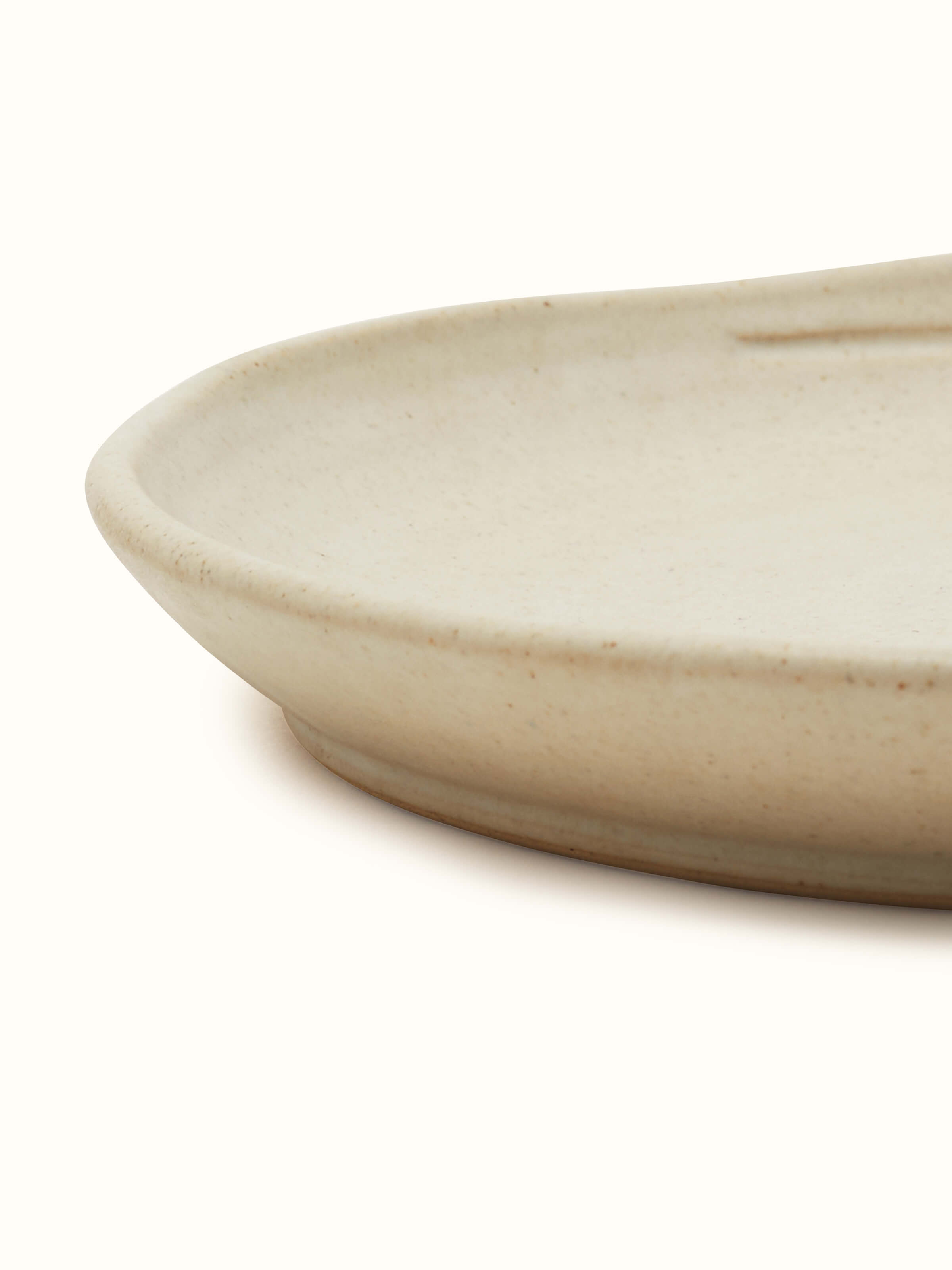 Side view of Studio Pottery Ceramic Dinner Plate Beige showing the depth and craftsmanship of the plate.