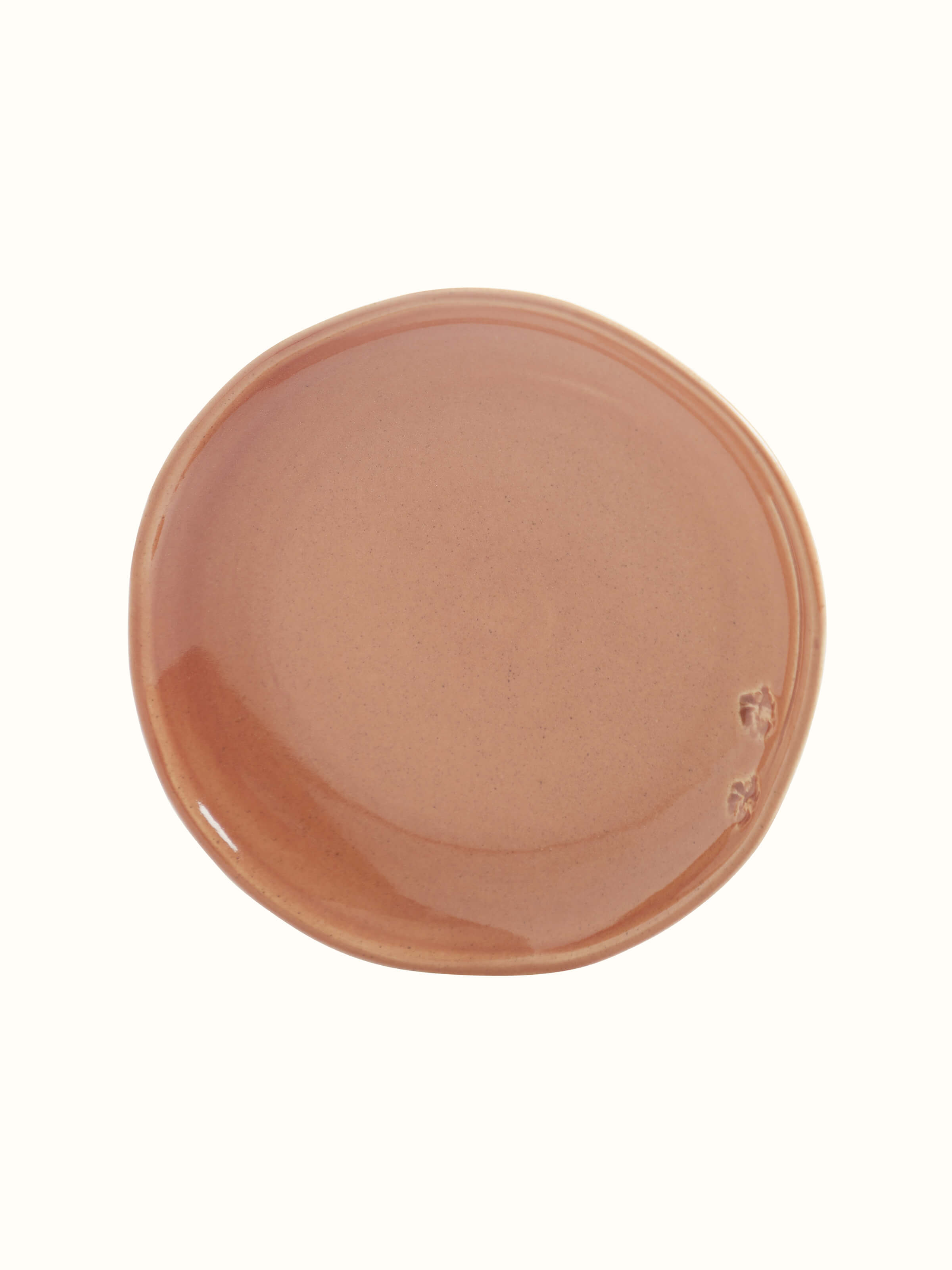 Angled view of studio pottery ceramic dessert plate in beige, emphasizing the delicate glaze and artisanal quality