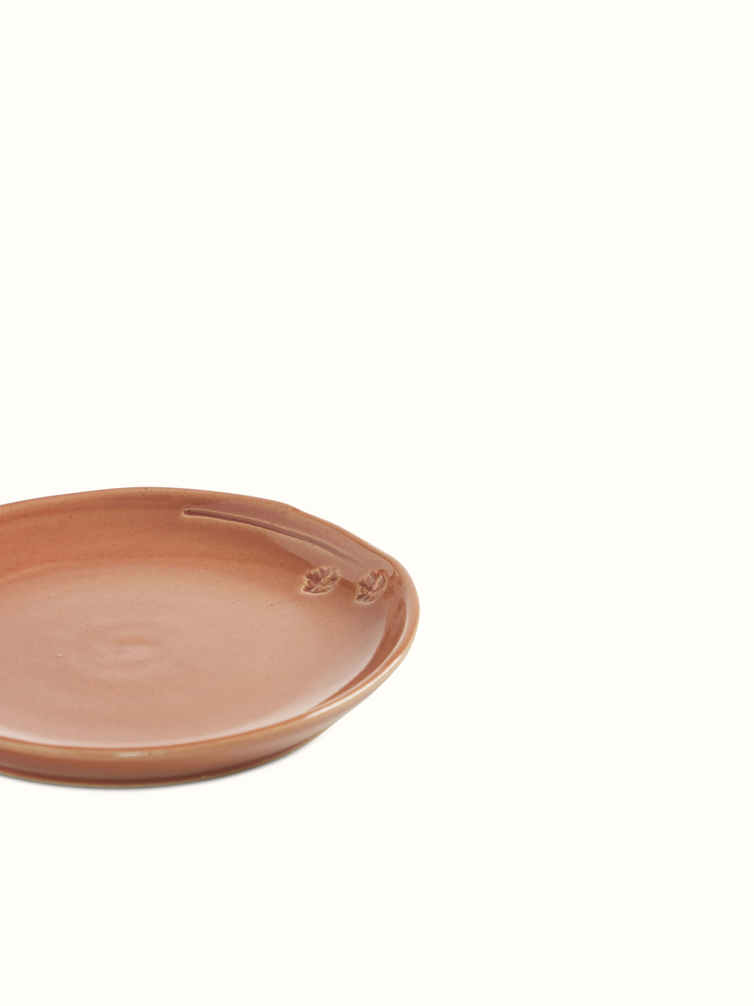 Close-up view of studio pottery ceramic dessert plate in beige, showcasing the smooth texture and artisanal details