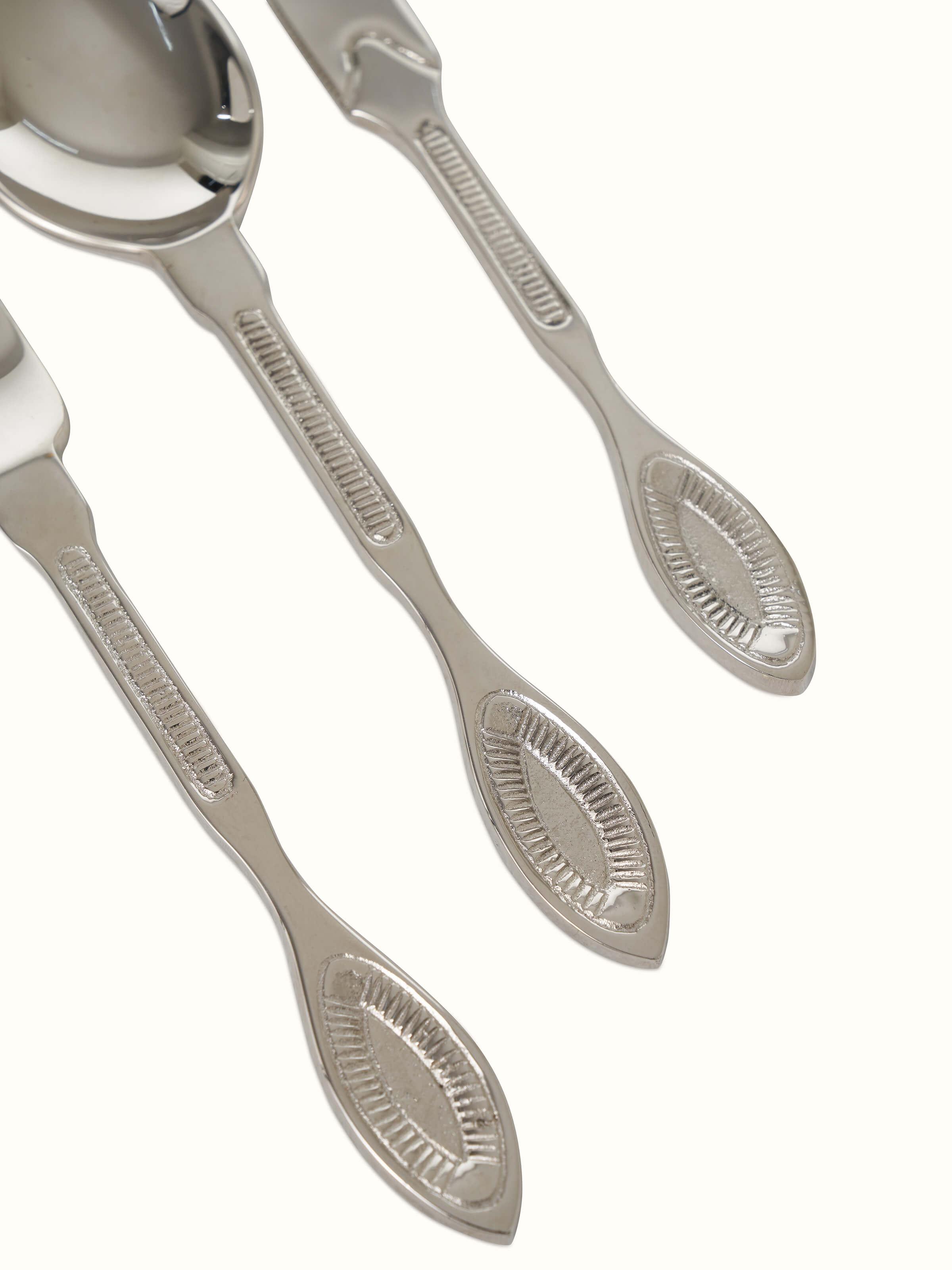 Detailed view of Nakkashi brass cutlery set with elegant design