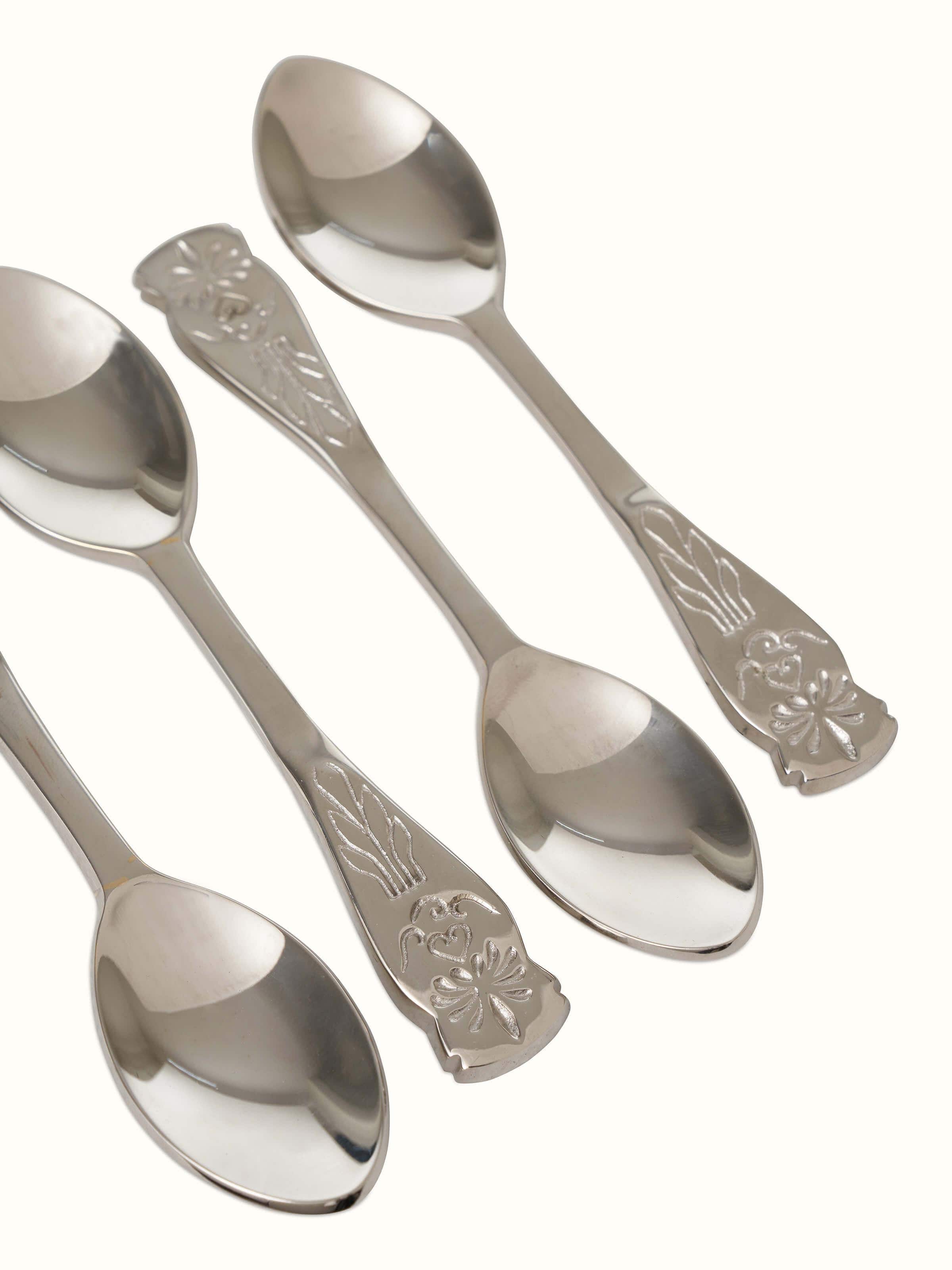 Close-up of brass teaspoons, focusing on the fine detailing and polished finish.
