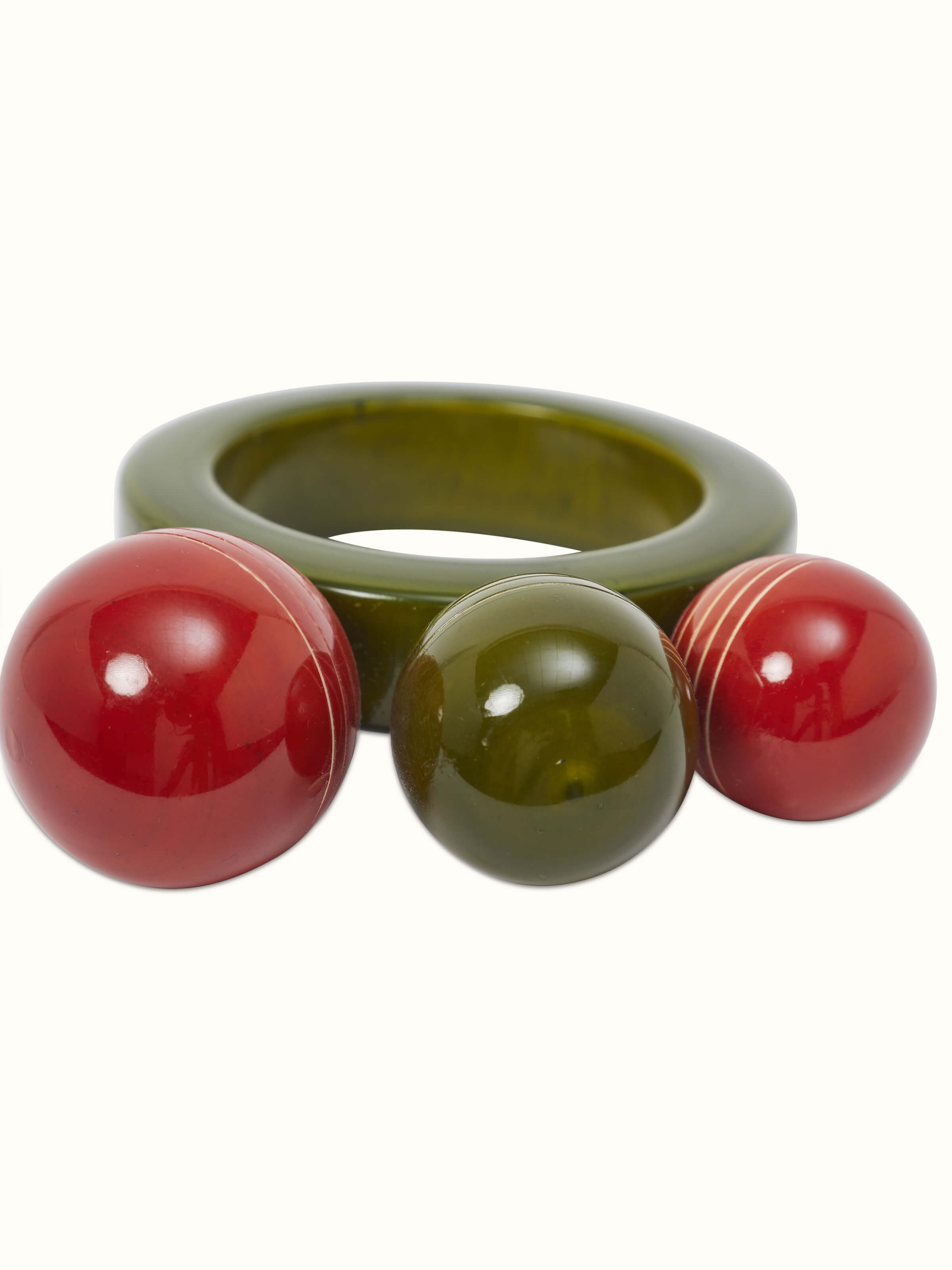 Channapatna ivory wood ball ring rattle toy showing the smooth texture and bright green color.
