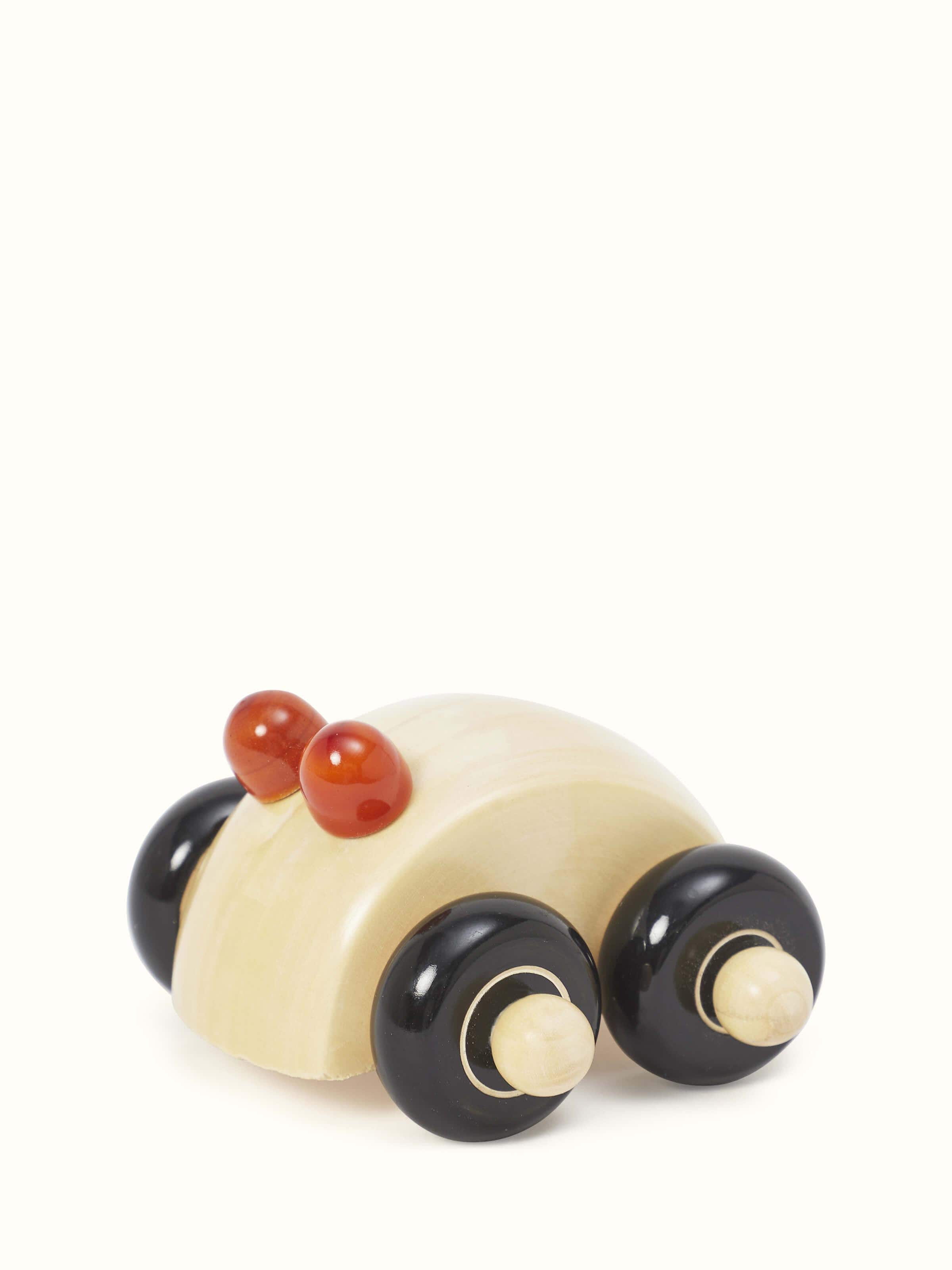 Angled view of Channapatna ivory wood round car toy in off-white color showcasing the detailed craftsmanship and functional design.
