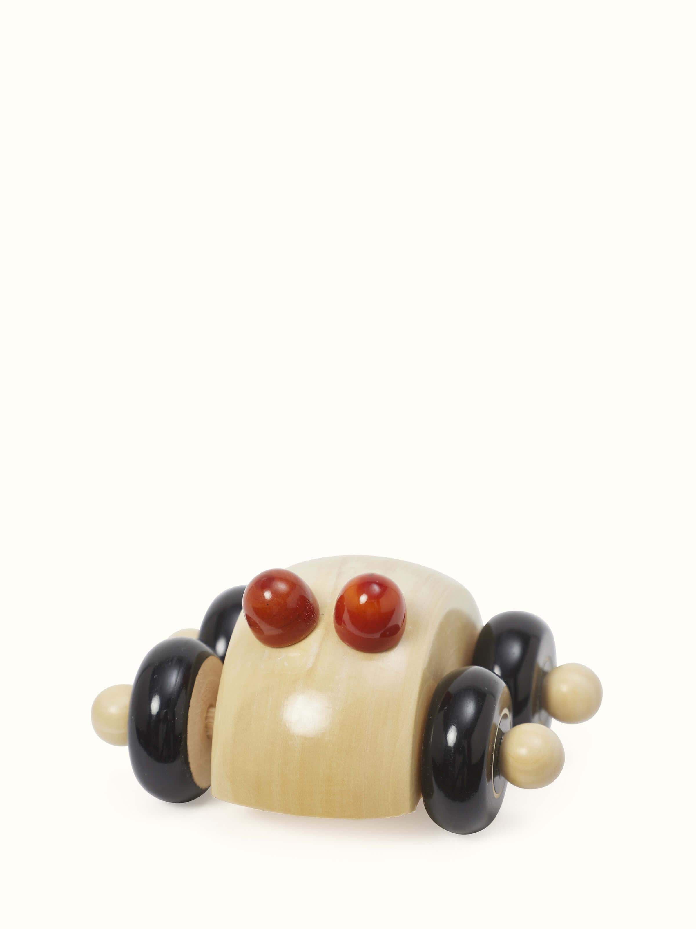 Close-up view of Channapatna ivory wood round car toy in off-white color focusing on the fine details and smooth wood finish.