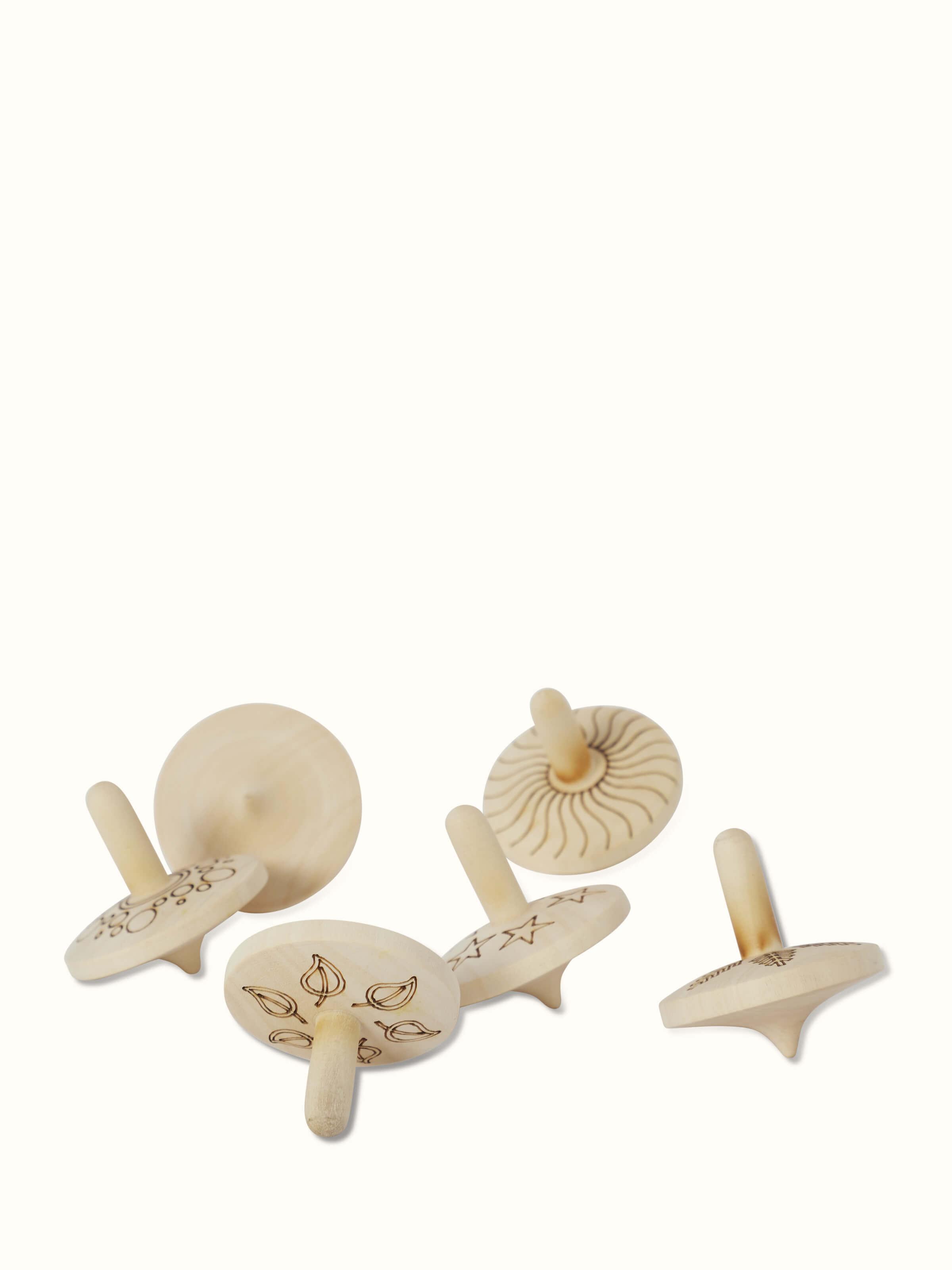 Side view of Channapatna Ivory Wood Spinning Top Toys in Off-White highlighting their classic design.