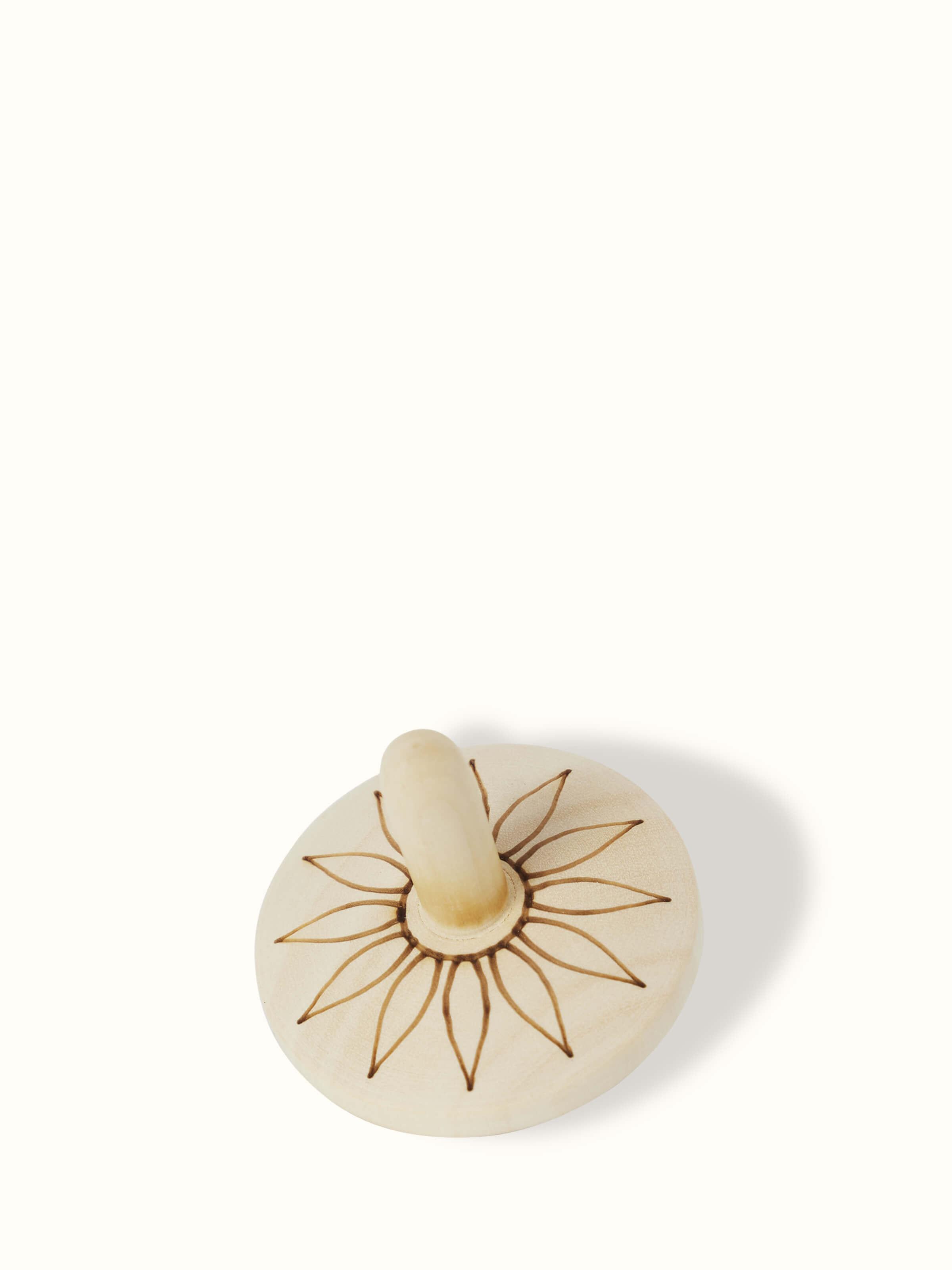 Side view of Channapatna Ivory Wood Spinning Top Toys in Off-White highlighting their classic appeal.
