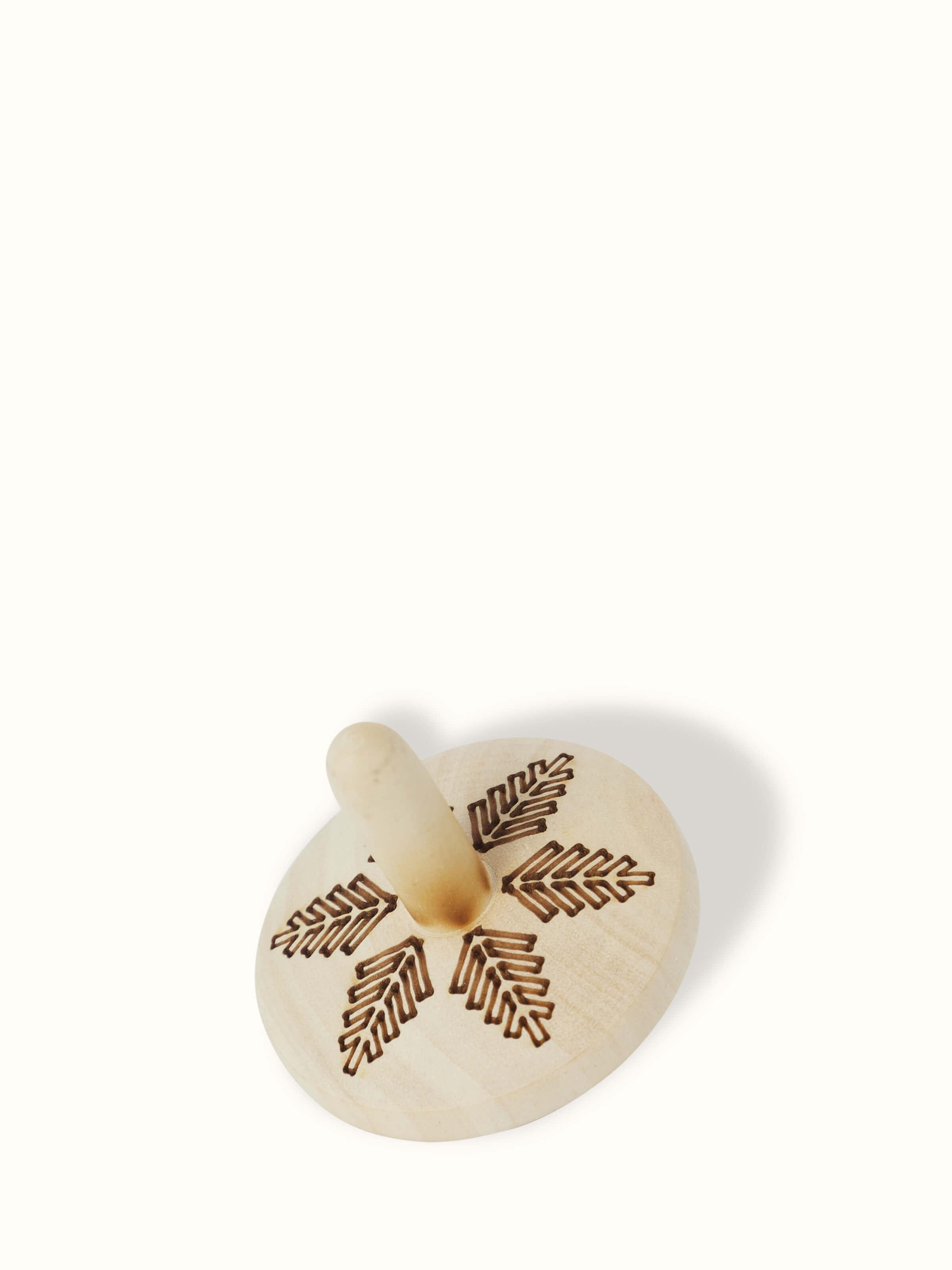 Close-up of Channapatna Ivory Wood Spinning Top Toys in Off-White showcasing fine craftsmanship.