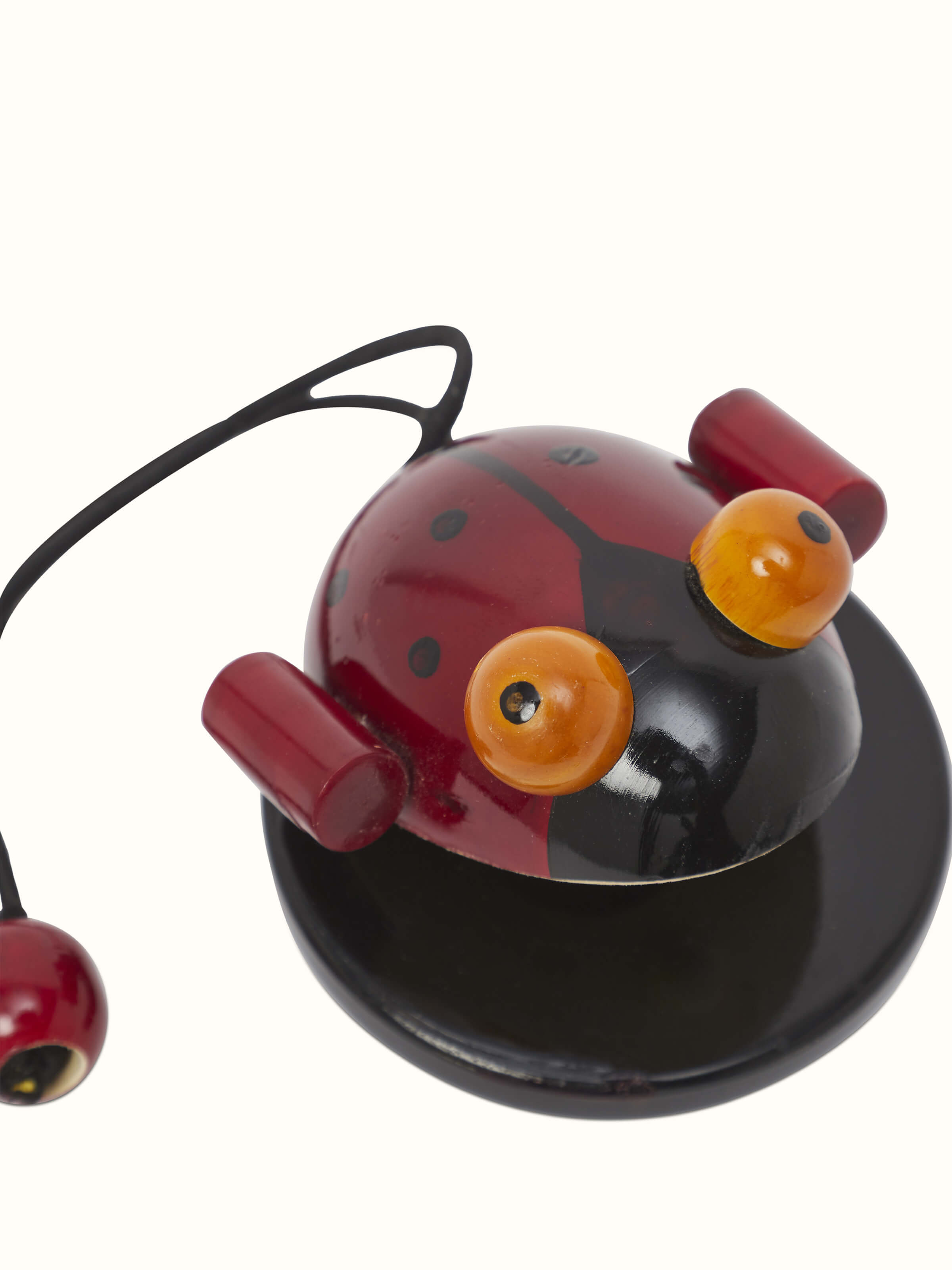 Close-up of Channapatna wooden noisy bug toy highlighting its craftsmanship and vibrant colors