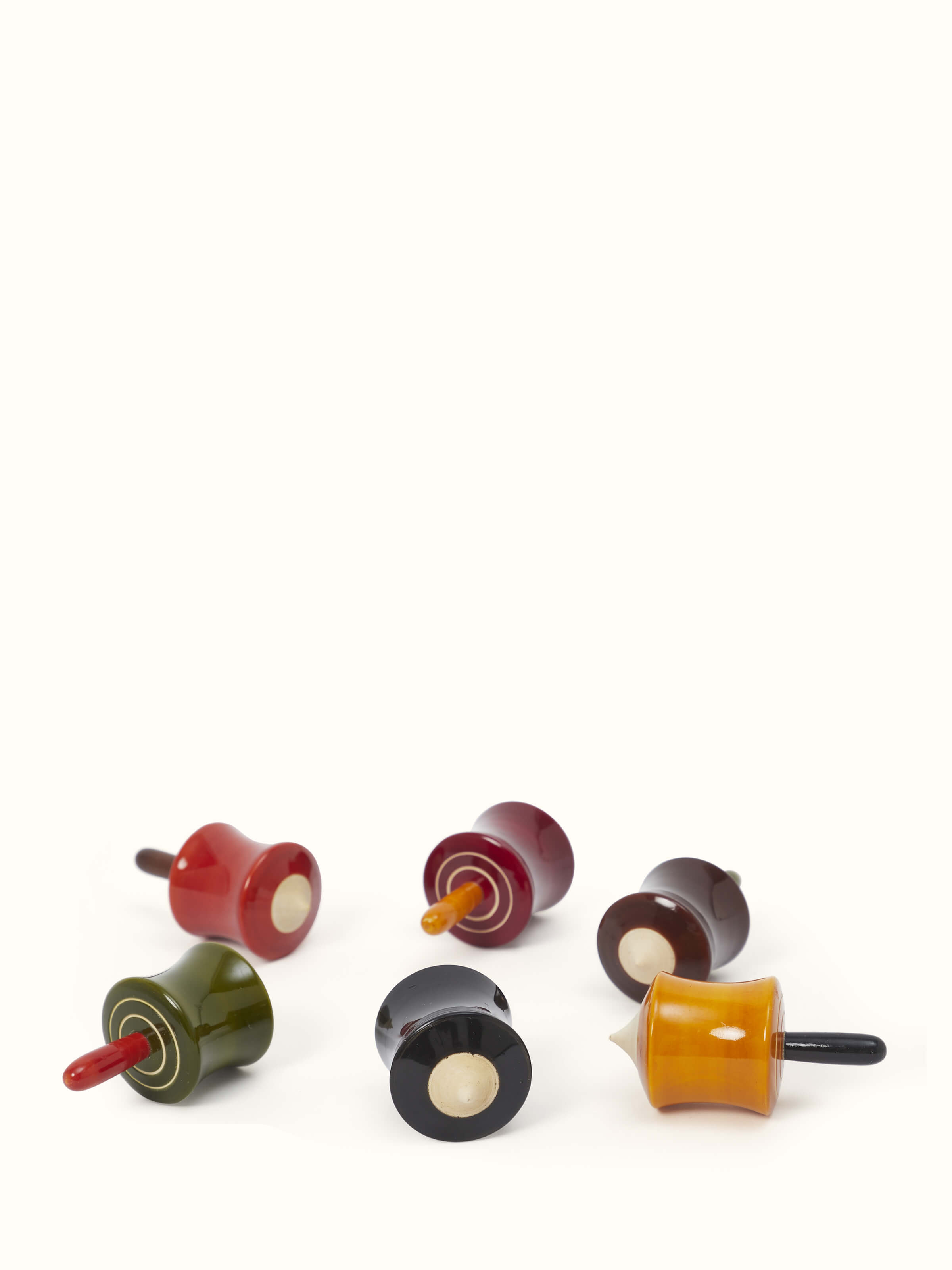 Set of six Channapatna ivory wood cylinder spinning toys, featuring traditional craftsmanship.