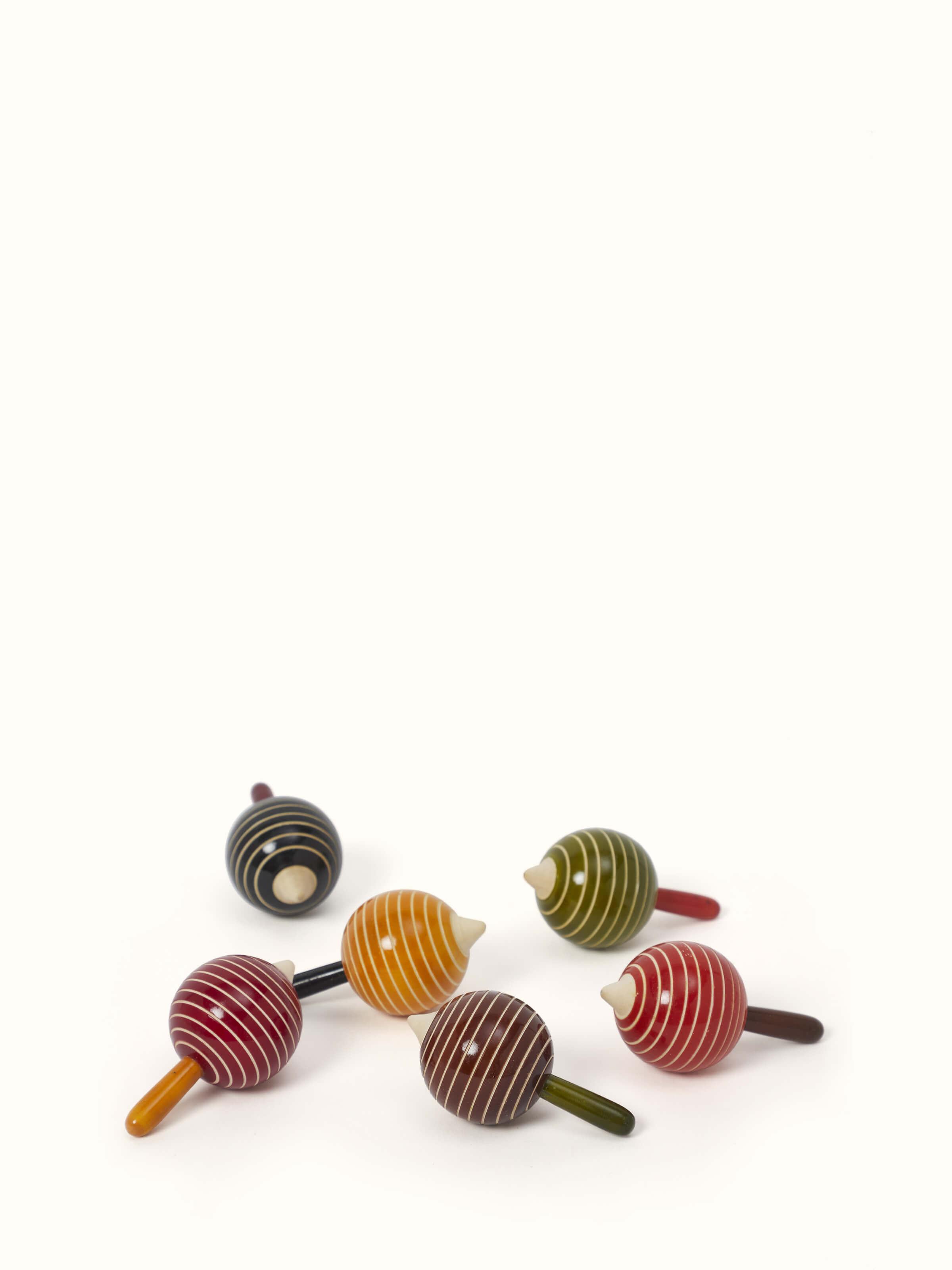 Front view of Channapatna ivory wood drop line apple spinning toys (6 pcs) showing vibrant colors and design.