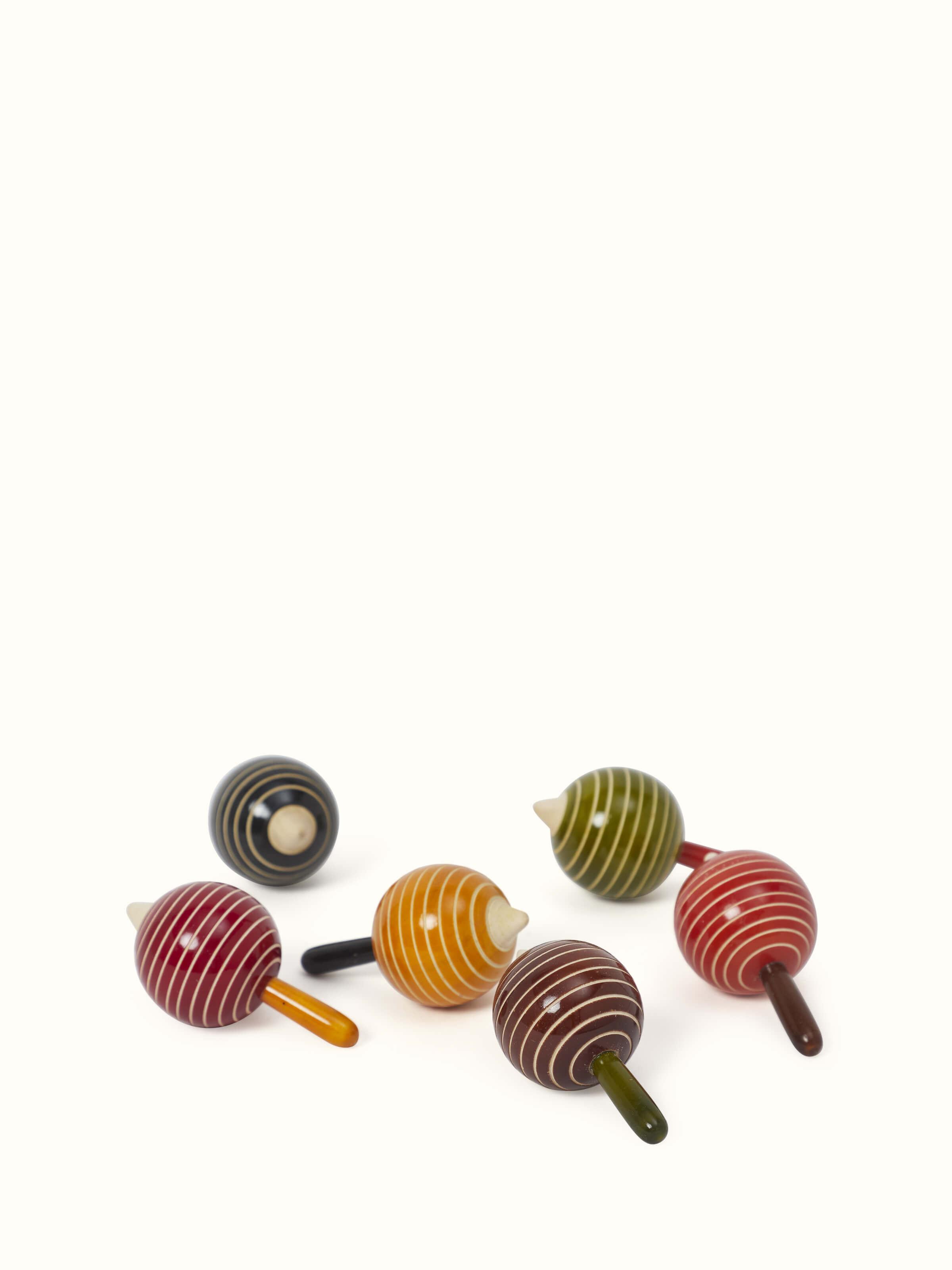 Side view of Channapatna ivory wood drop line apple spinning toys (6 pcs) showcasing their intricate details.