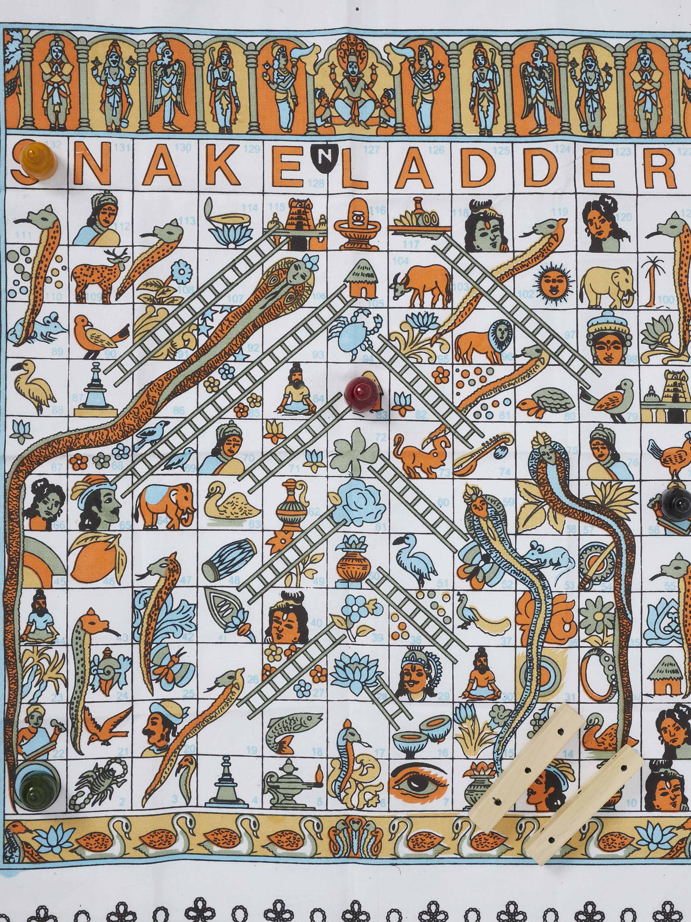 Top view of Channapatna ivory wood snake and ladders board game in white