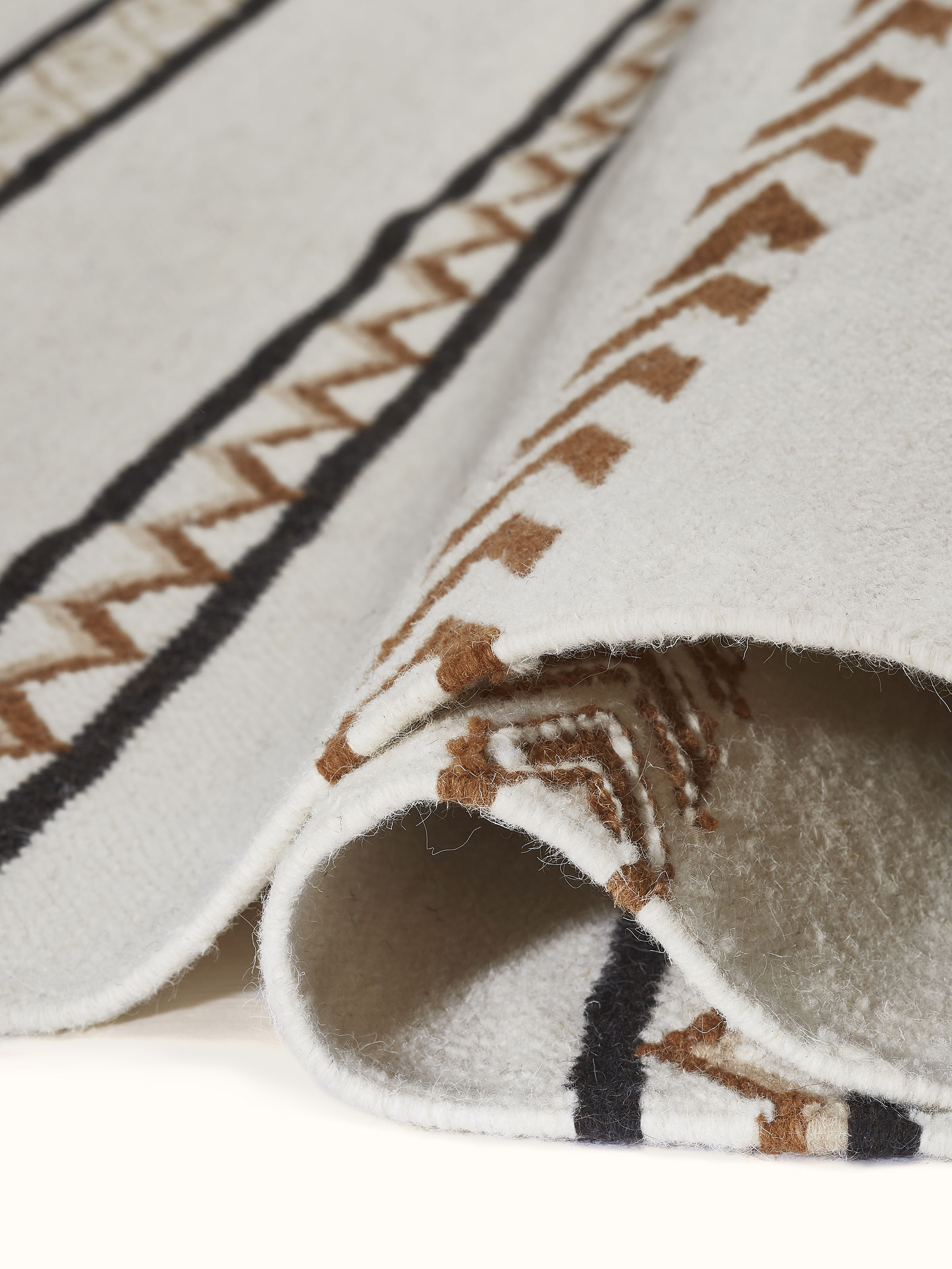 Detailed view of the Geo stripes ivory Gujarat wool & cotton panja dhurrie kharad, emphasizing the dhurrie's thickness and wool-cotton blend