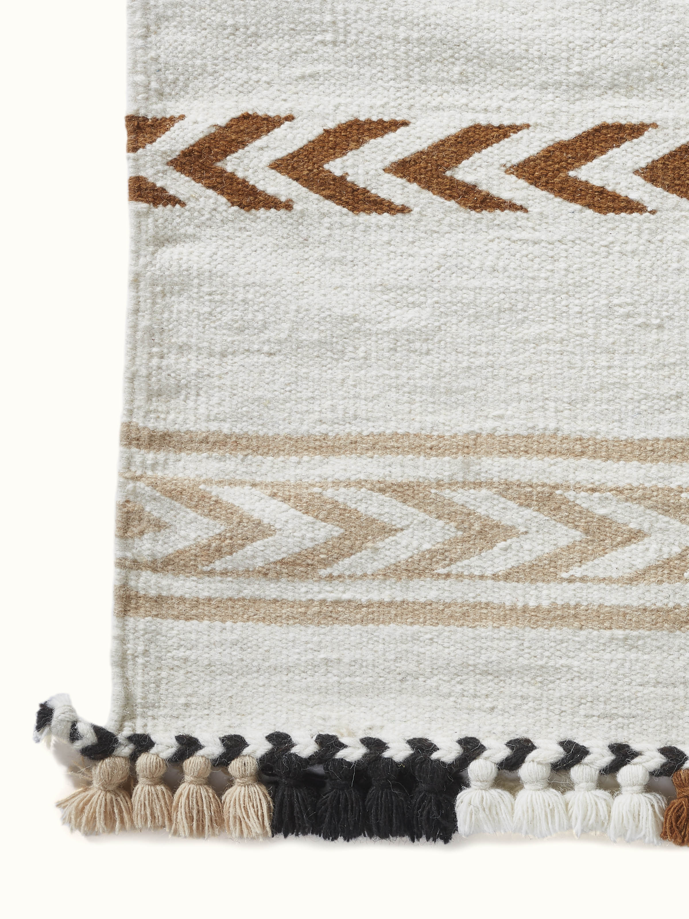 Side view of Geo stripes ivory Gujarat wool & cotton panja dhurrie kharad, showcasing the dhurrie's edge and fabric structure