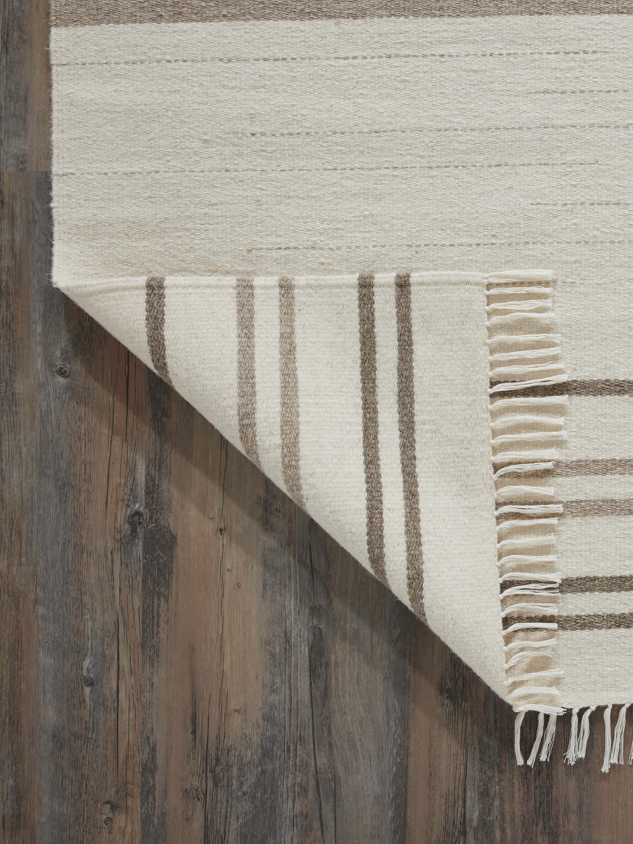 Close-up of Nomad Stripes Ivory Beige Jawaja wool & cotton handloom dhurrie focusing on the fabric texture and stripe design.