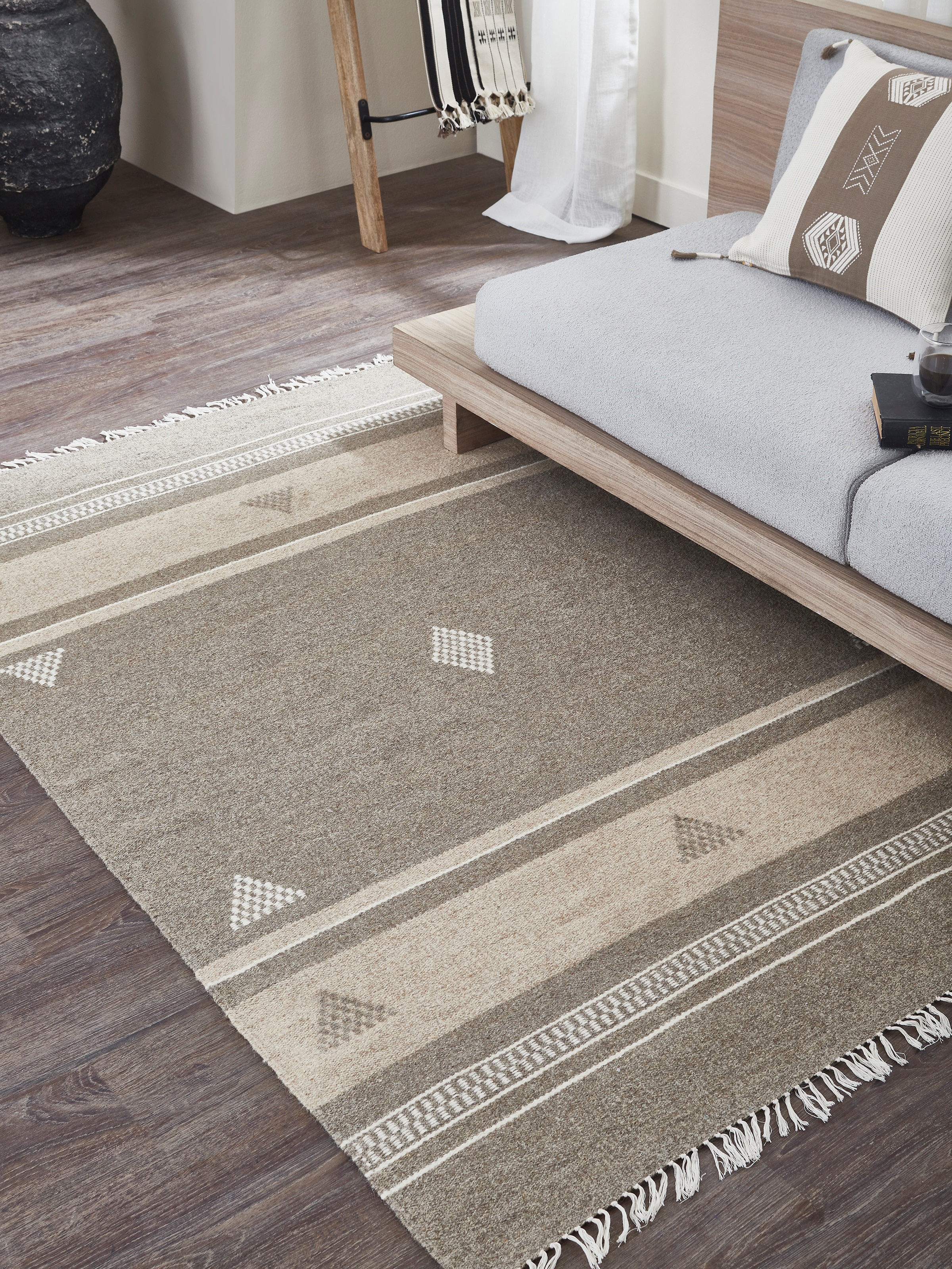 Lifestyle view of beige Jawaja wool dhurrie with striped and buti patterns in 4X6 ft size.