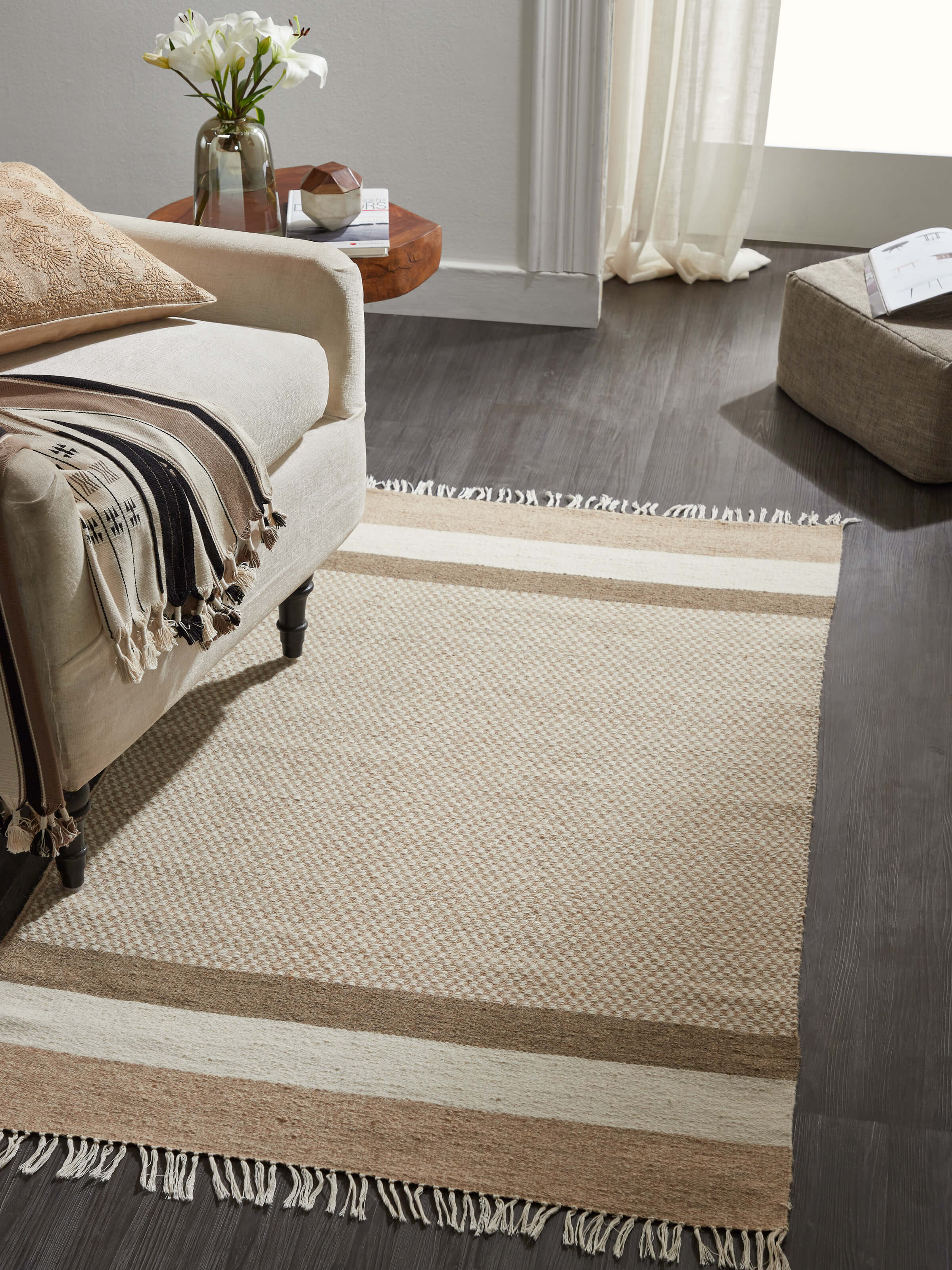 Lifestyle image of 4x6 ft beige checkered wool Jawaja handloom dhurrie on wooden flooring