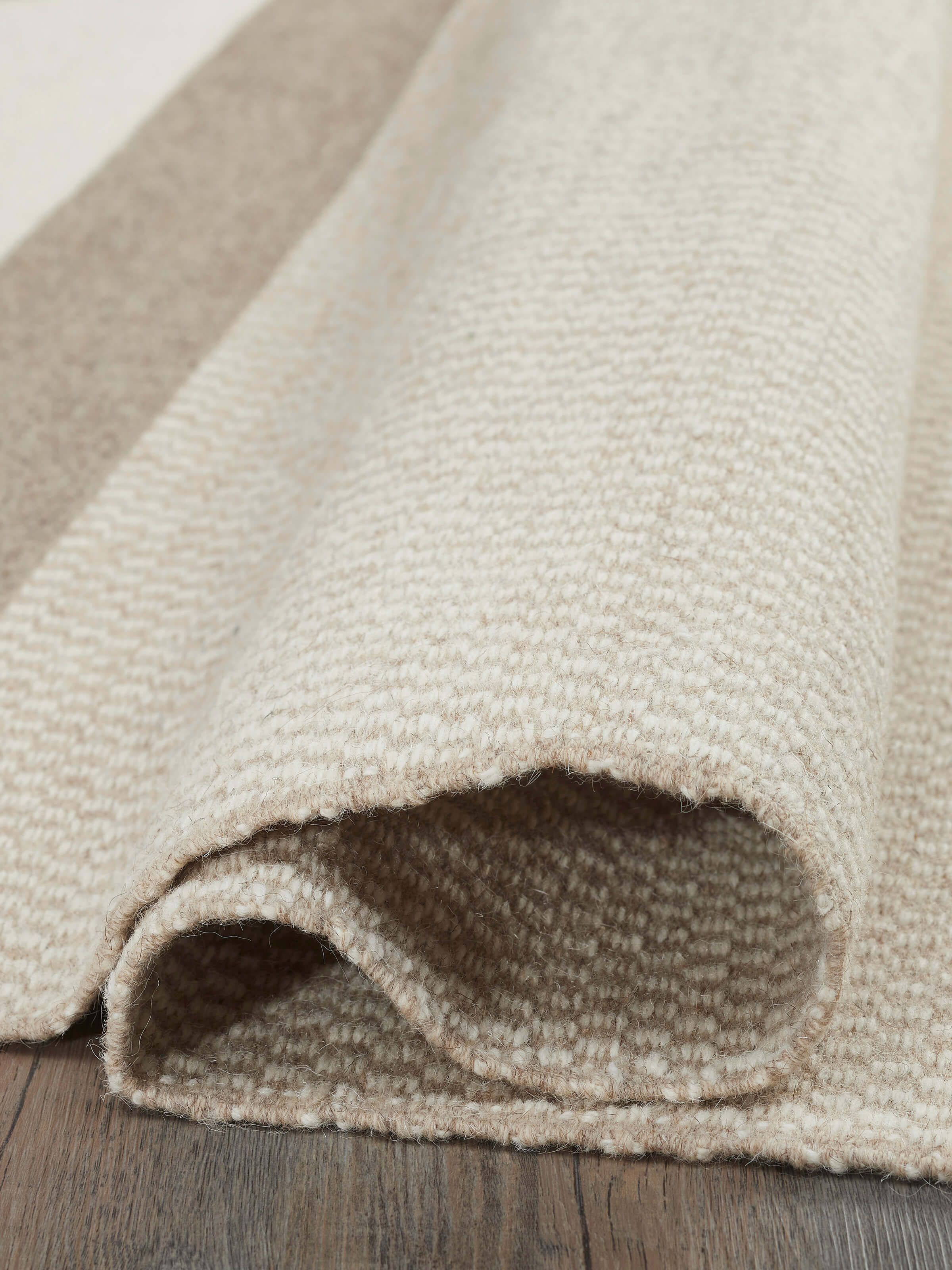 Side view of Geo checkered beige Jawaja wool & cotton handloom dhurrie (4x6 ft) focusing on the thickness and checkered design.