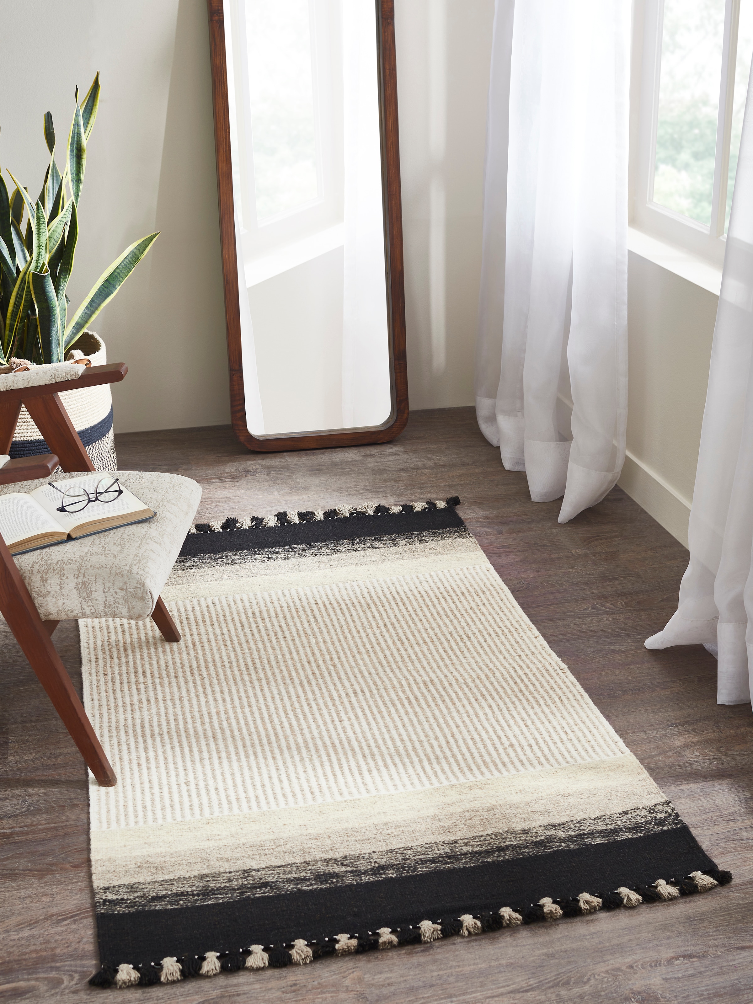 Lifestyle view of Textured Stripes Beige Black Jawaja Wool Handloom Dhurrie (3X5 Ft), showing its bold striped design and wool texture.