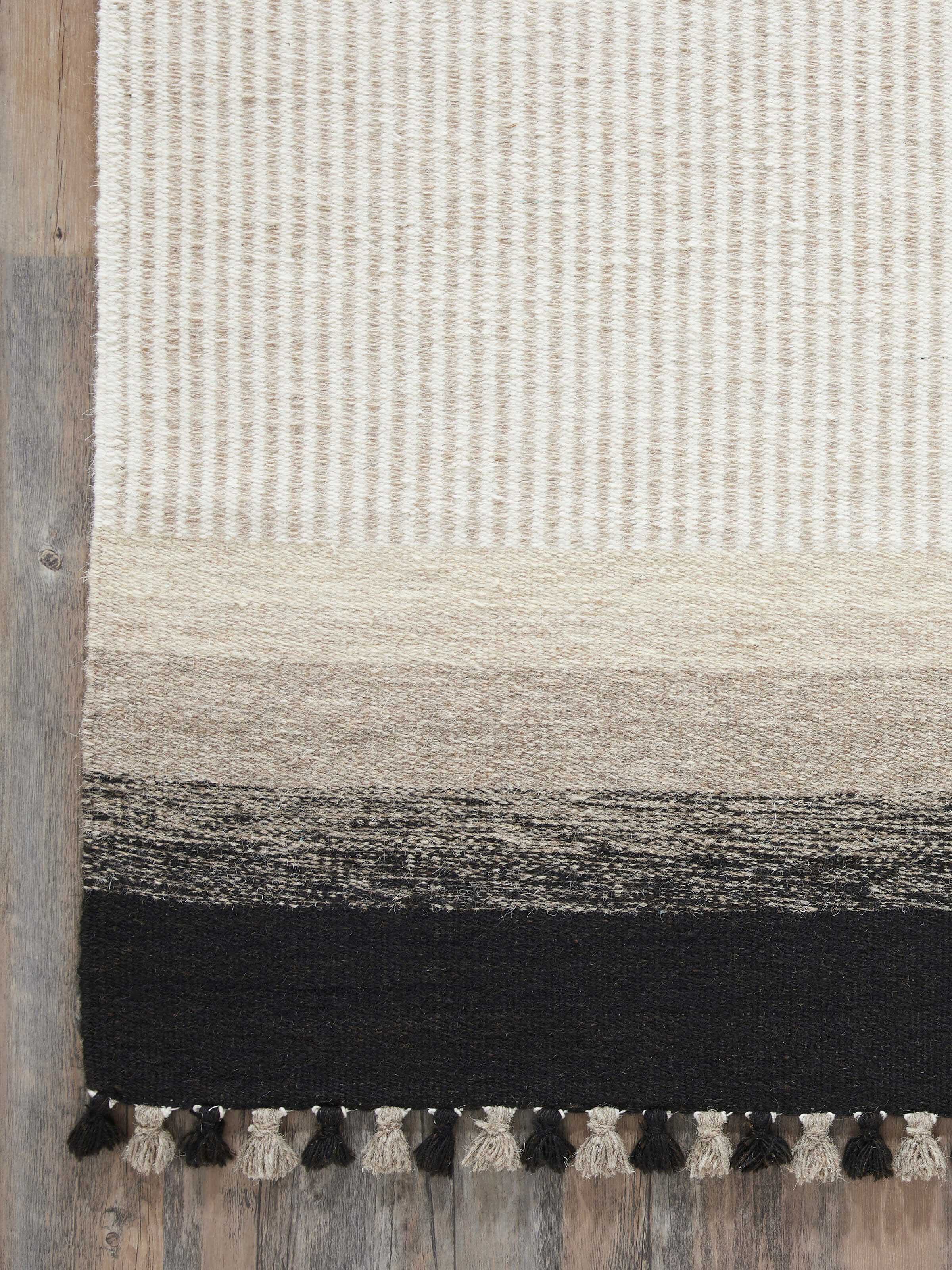 Angled view of Textured Stripes Beige Black Jawaja Wool & Cotton Handloom Dhurrie, displaying the overall design and texture.