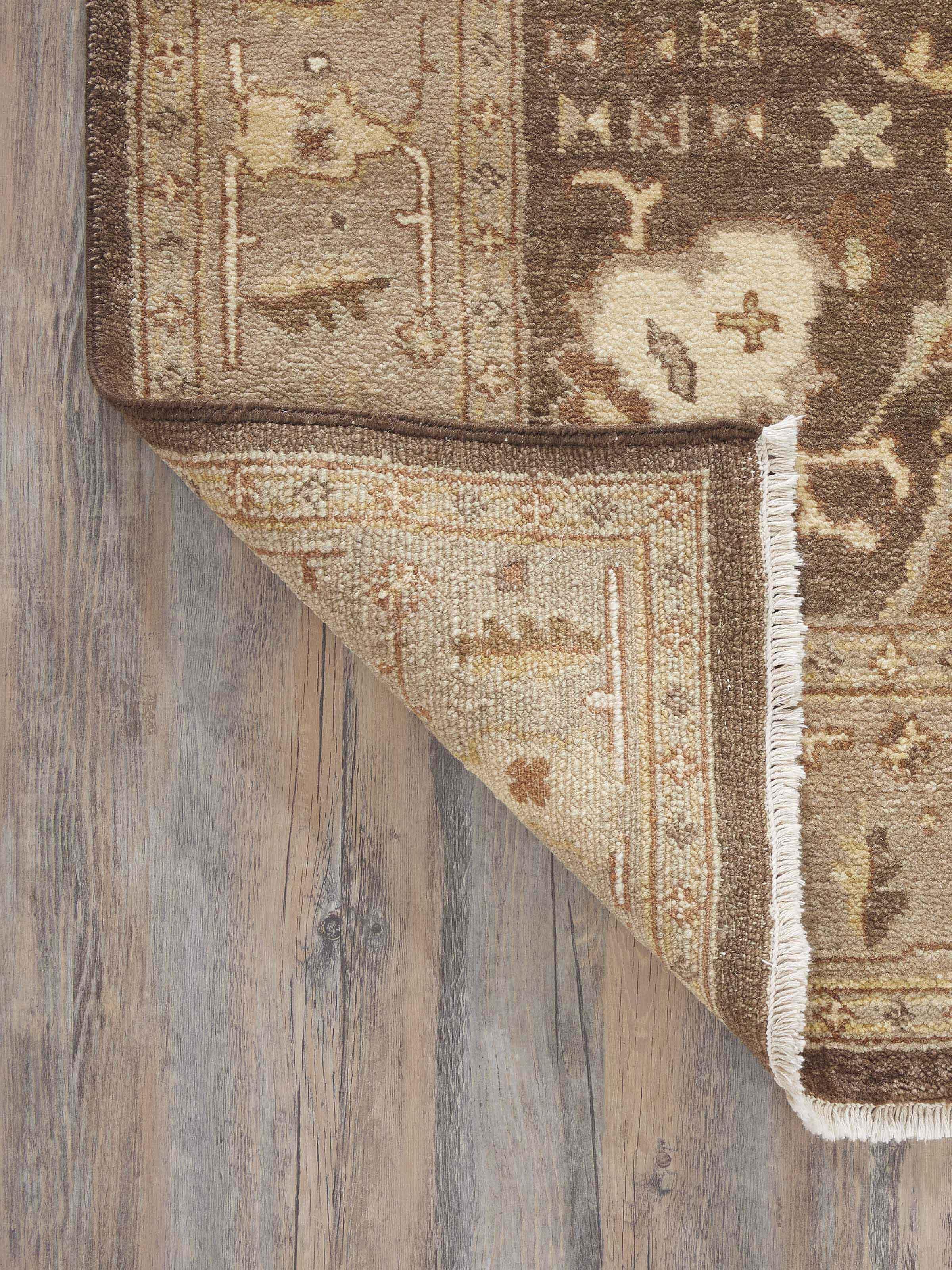 Full layout of Oushak traditional brown Jaipur wool hand-knotted rug on a floor, showcasing its size and pattern in context.