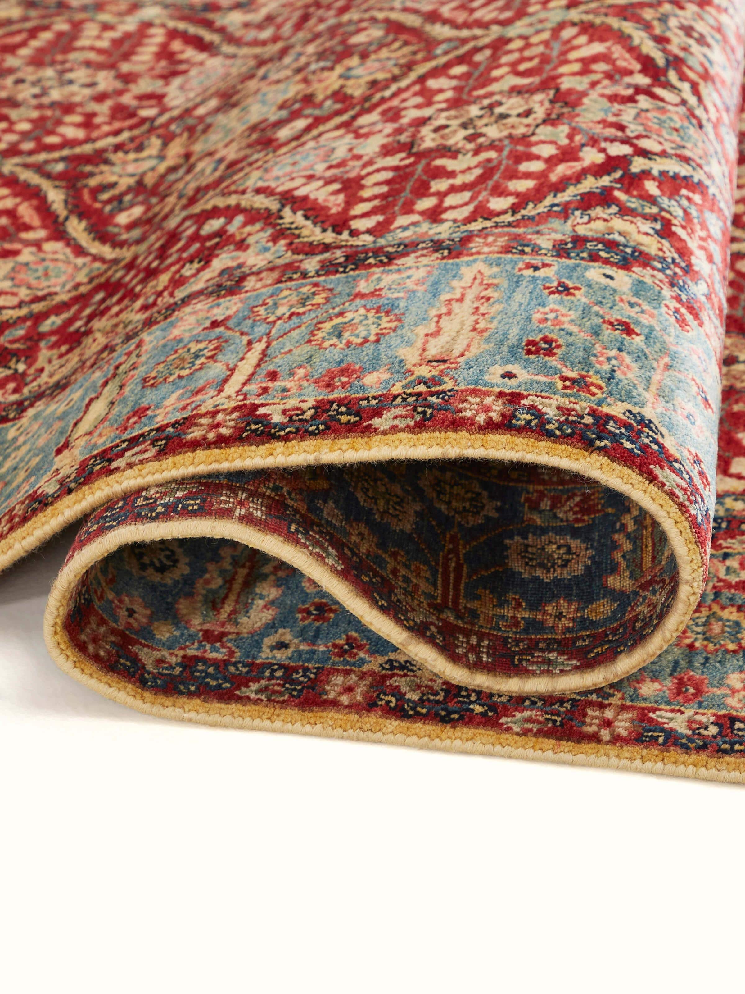 Angled design-focused view of red hand-knotted wool runner with Ziegler motifs