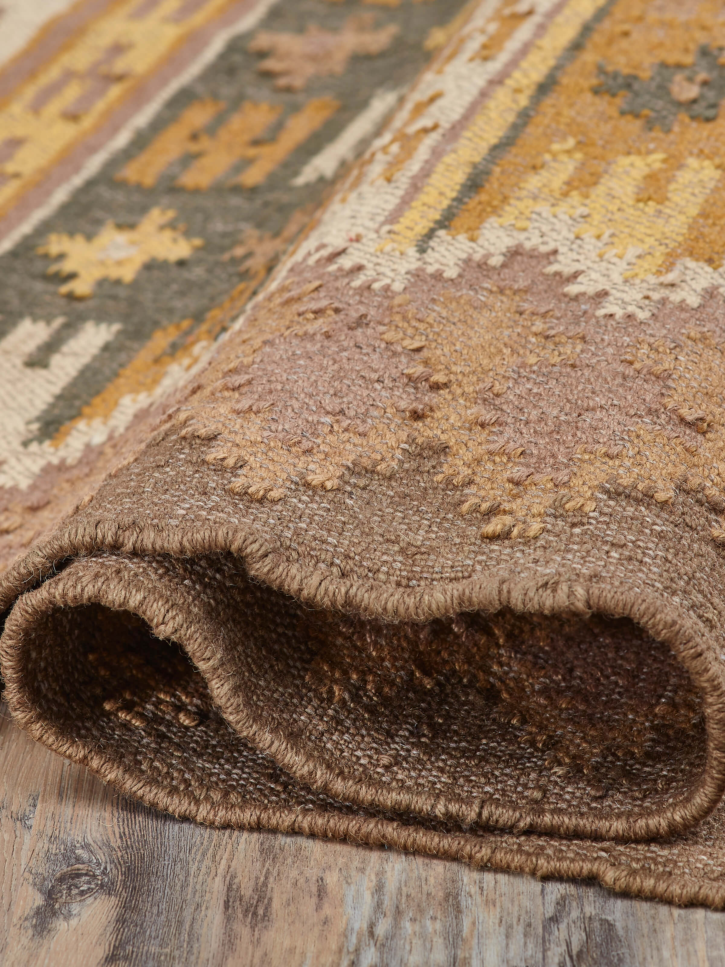 Close-up of the kilim design on a brown jute & wool panja dhurrie, emphasizing the traditional weaving technique.