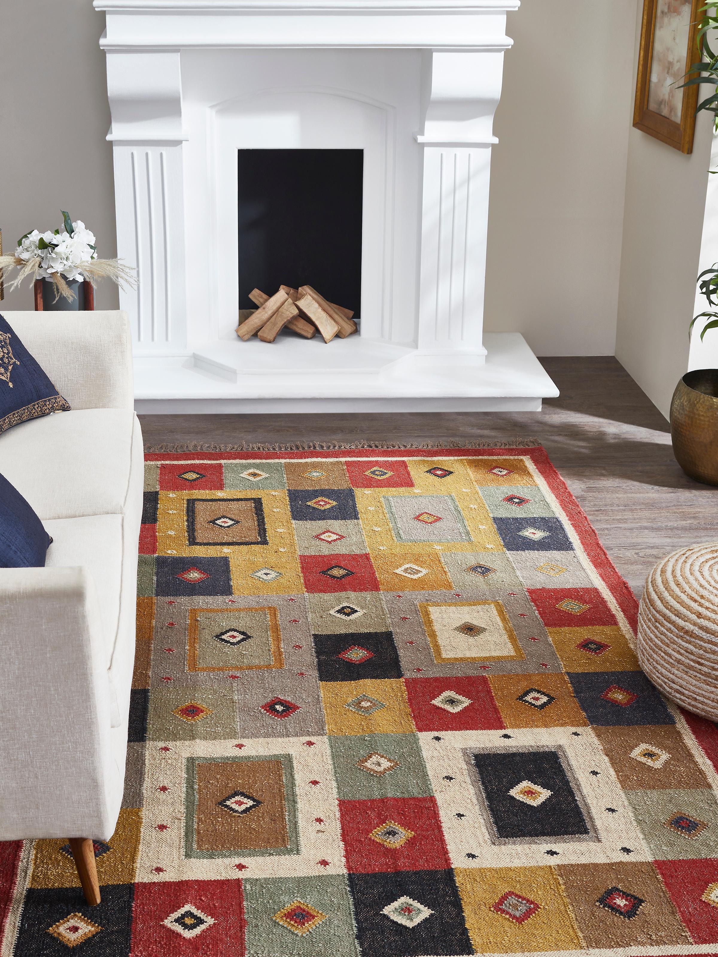 Living space shot of color-blocked Lawan jute Panja dhurrie with earthy tones and geometric design.