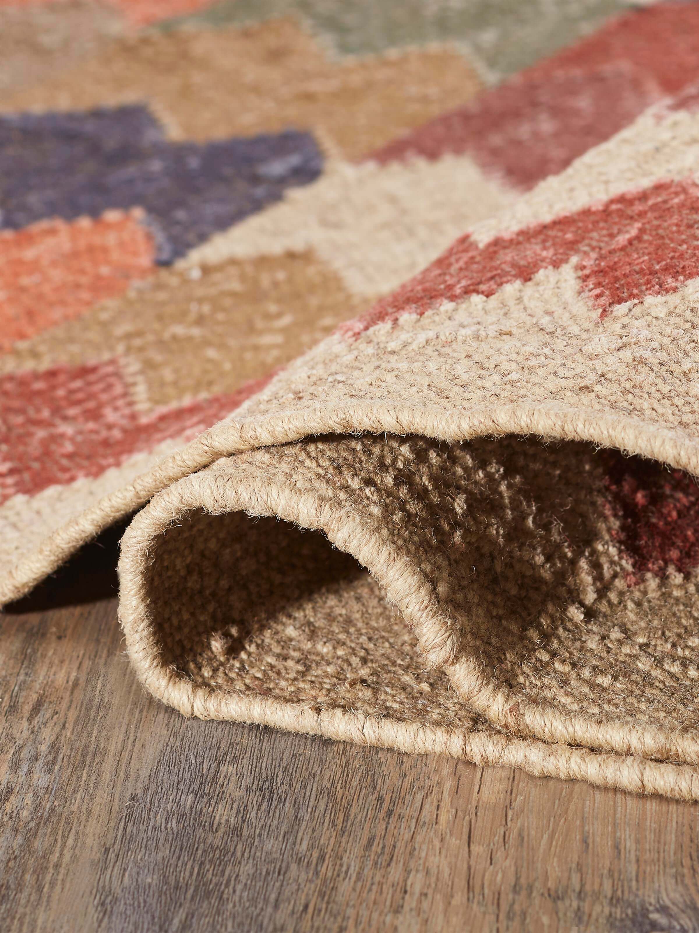 Angled view of Geo Chevrons Jute & Wool Panja Dhurrie, displaying the full chevron pattern and fabric texture.