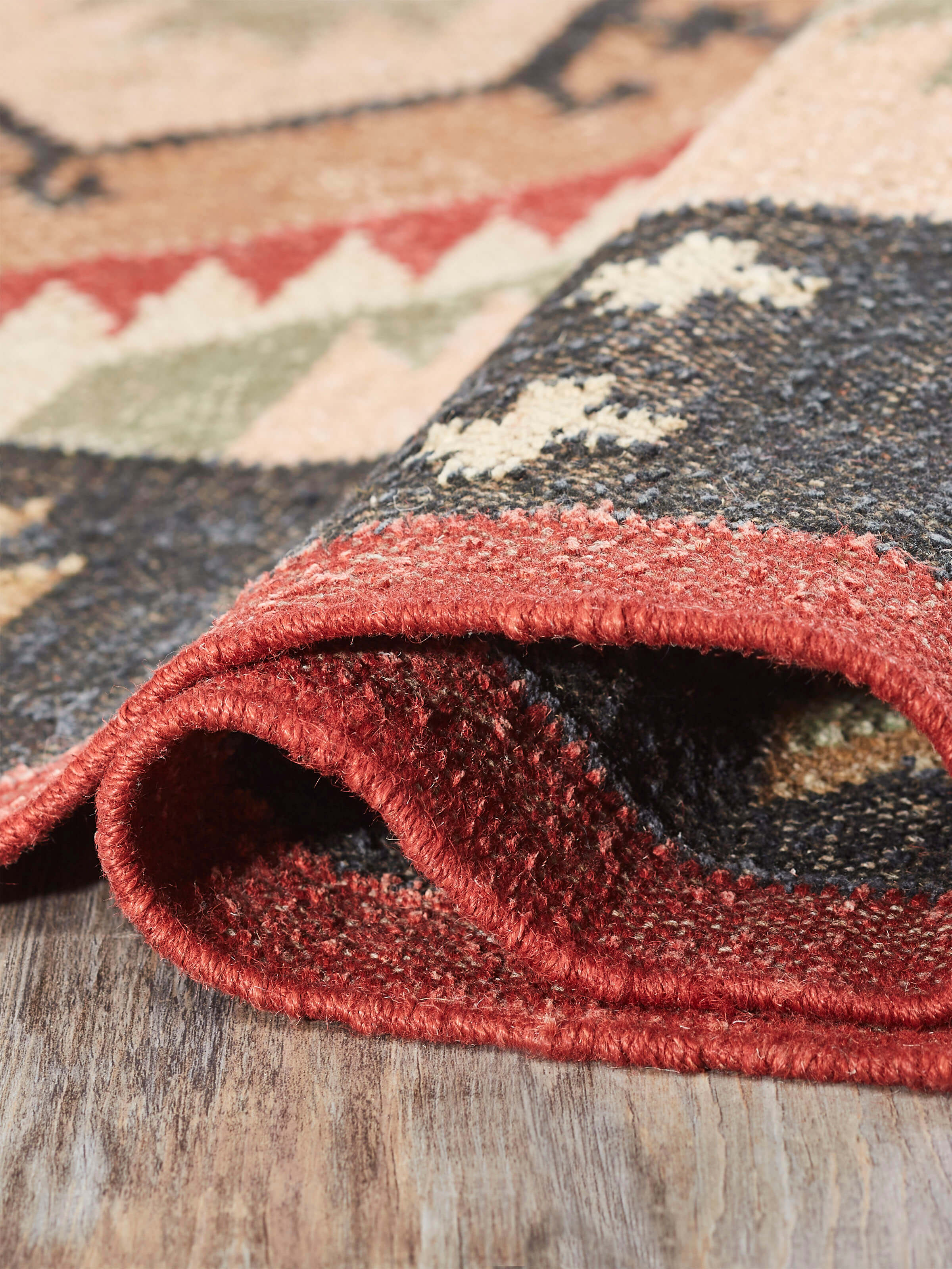 Traditional Kilim Black Lawan jute & wool panja dhurrie folded, showcasing the texture and pattern details.