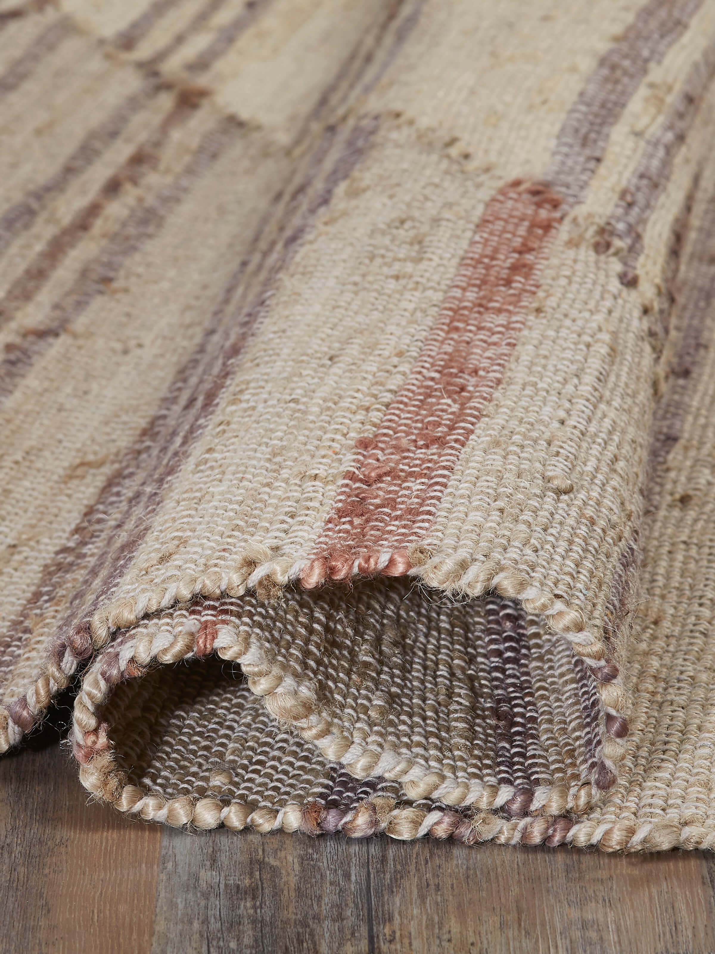 Side view highlighting the Geo Stripes beige brown jute & cotton natural fibre rug's edge and design