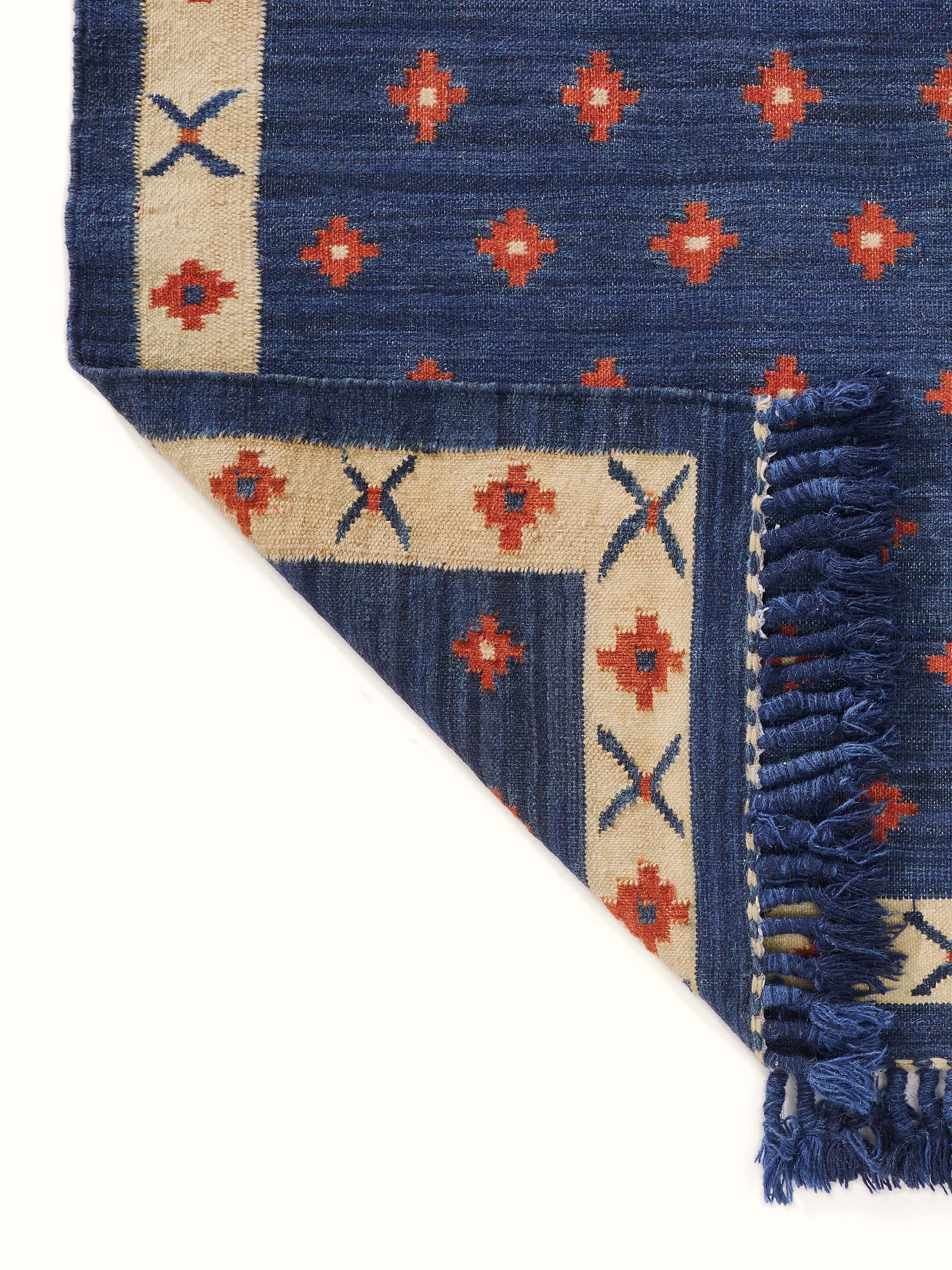Detailed view of the dotted diamond blue rust salawas wool & cotton panja dhurrie showing the fabric's intricate design