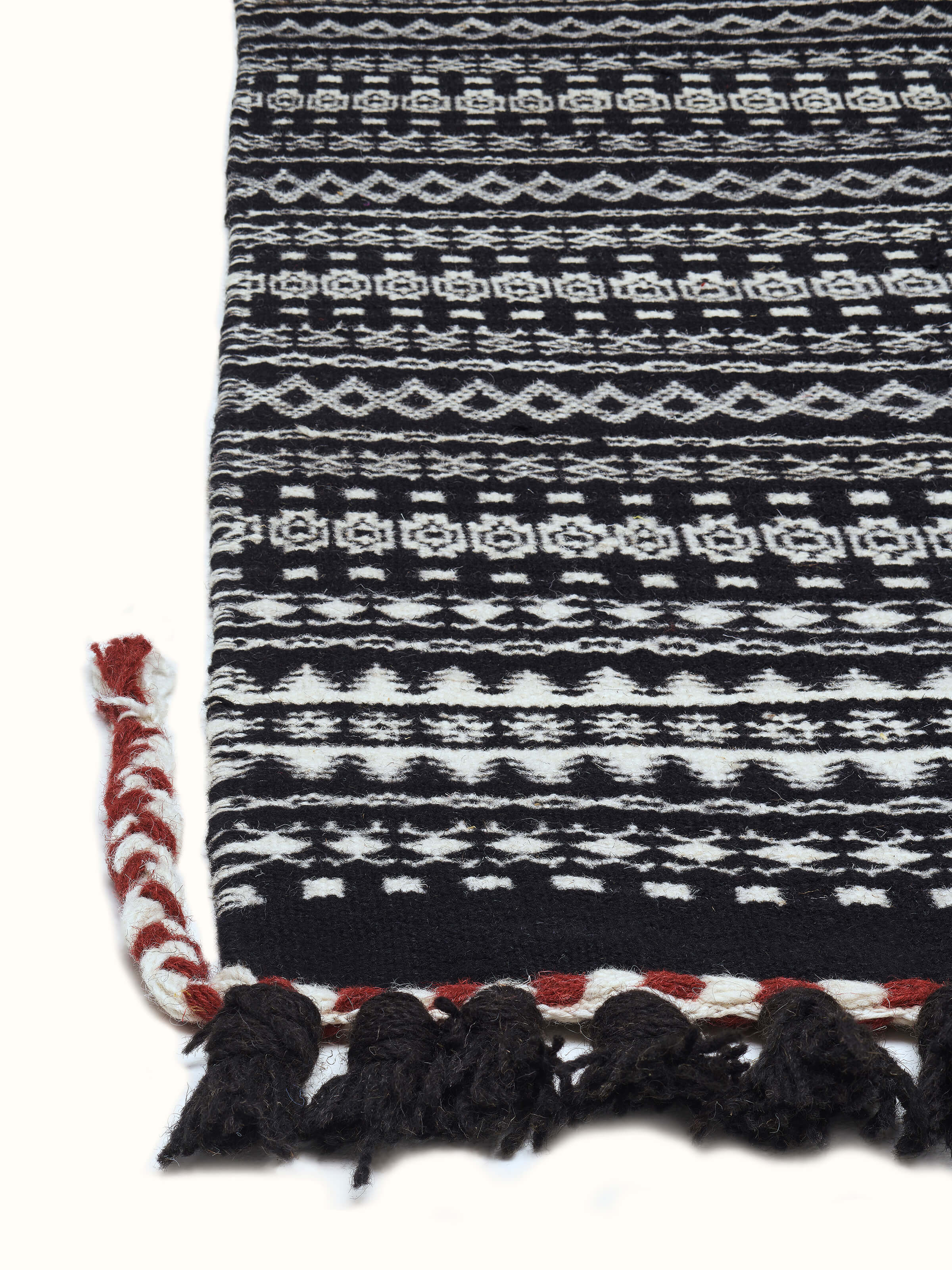 Angled view of Sindhi textured ivory black salawas wool panja dhurrie, displaying its full design and luxurious wool texture.