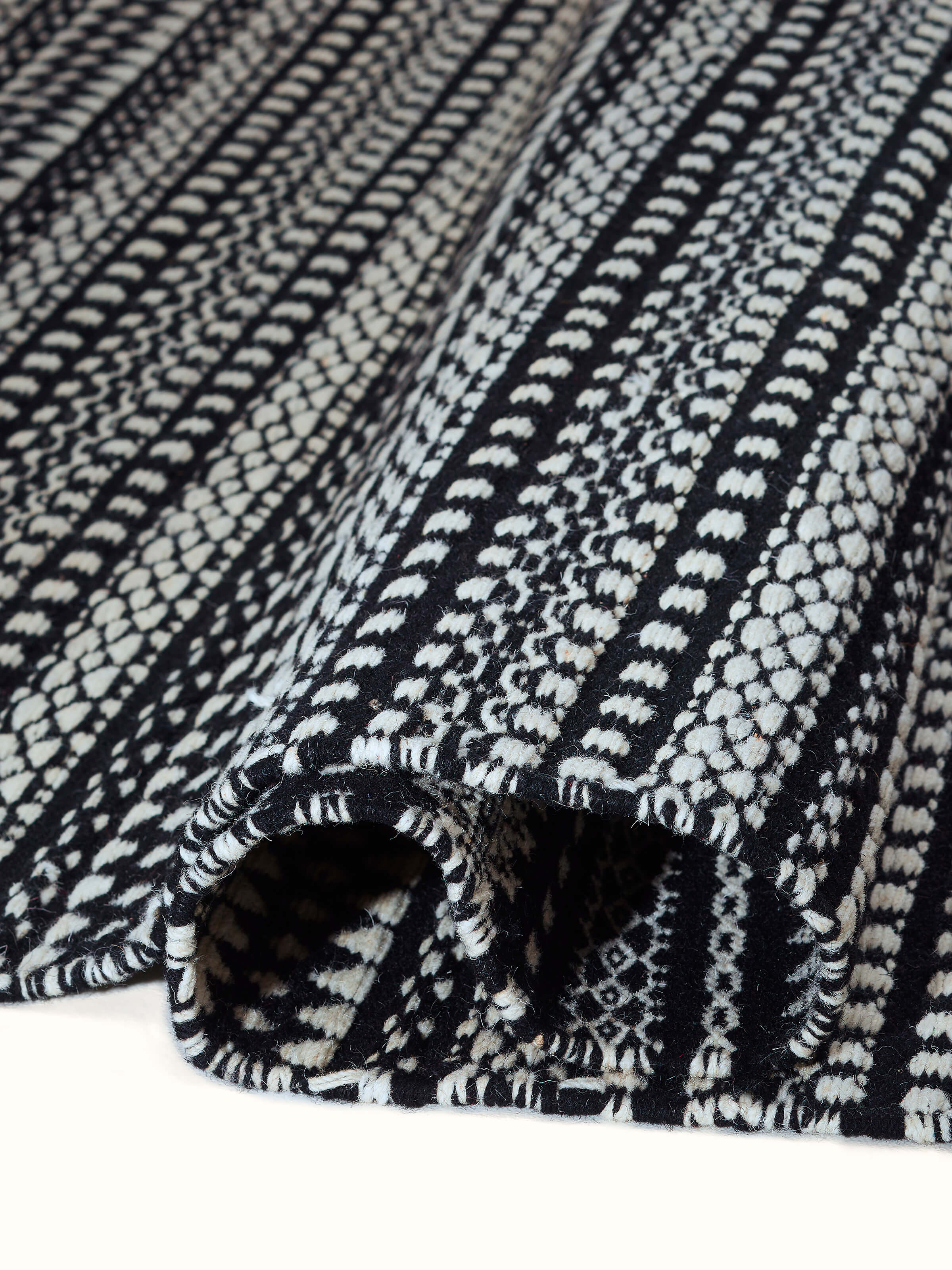 Detailed view of Sindhi textured ivory black salawas wool panja dhurrie, highlighting the fine craftsmanship and material quality.