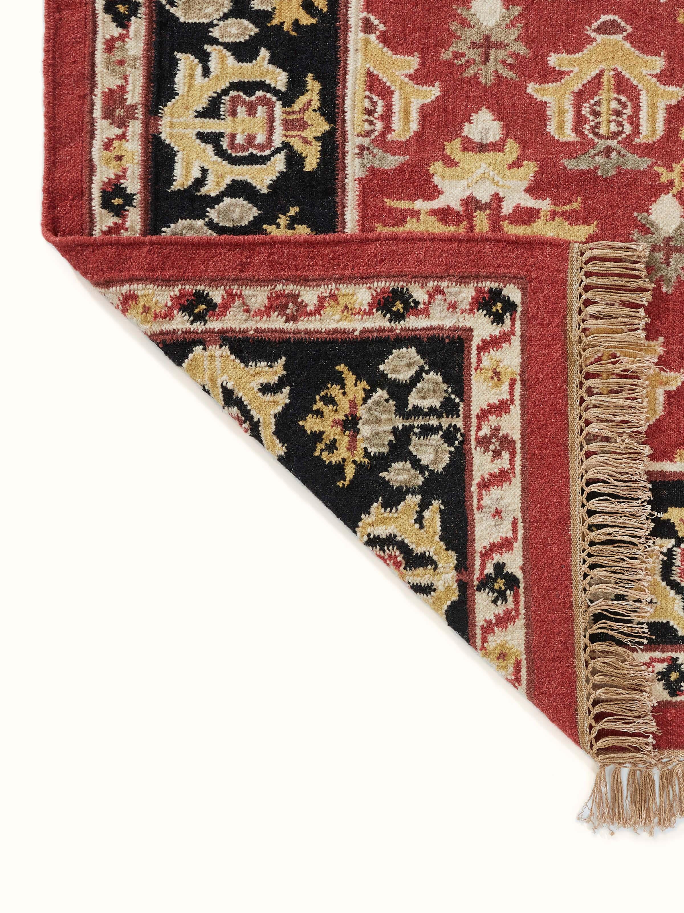 Detailed view of Traditional floral kilim rust salawas wool & cotton panja dhurrie highlighting the geometric and floral elements