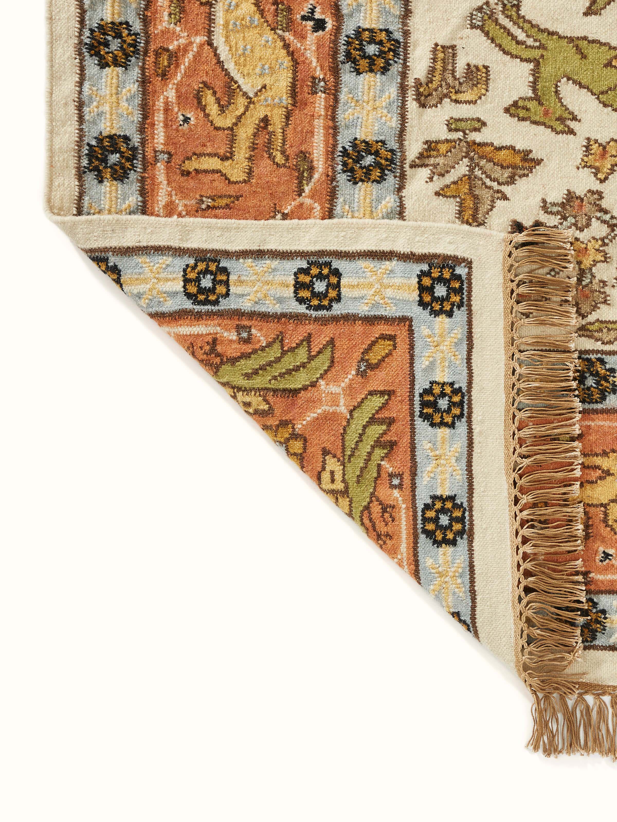 View of Kilim hunting salawas wool & cotton panja dhurrie in a living space, showing its texture and design.