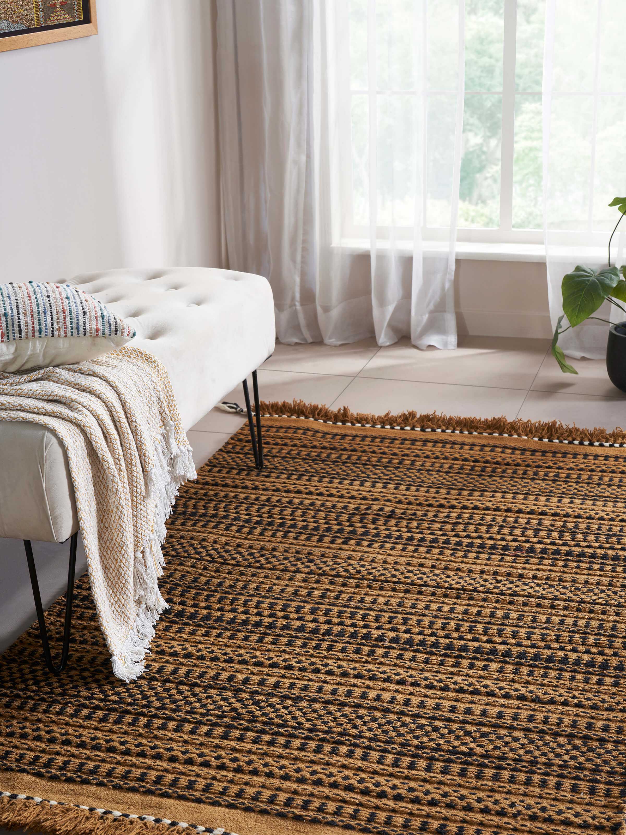 Close-up view of Sindhi textured orange salawas wool & cotton panja dhurrie, showing the detailed texture and weaving style in orange hues.