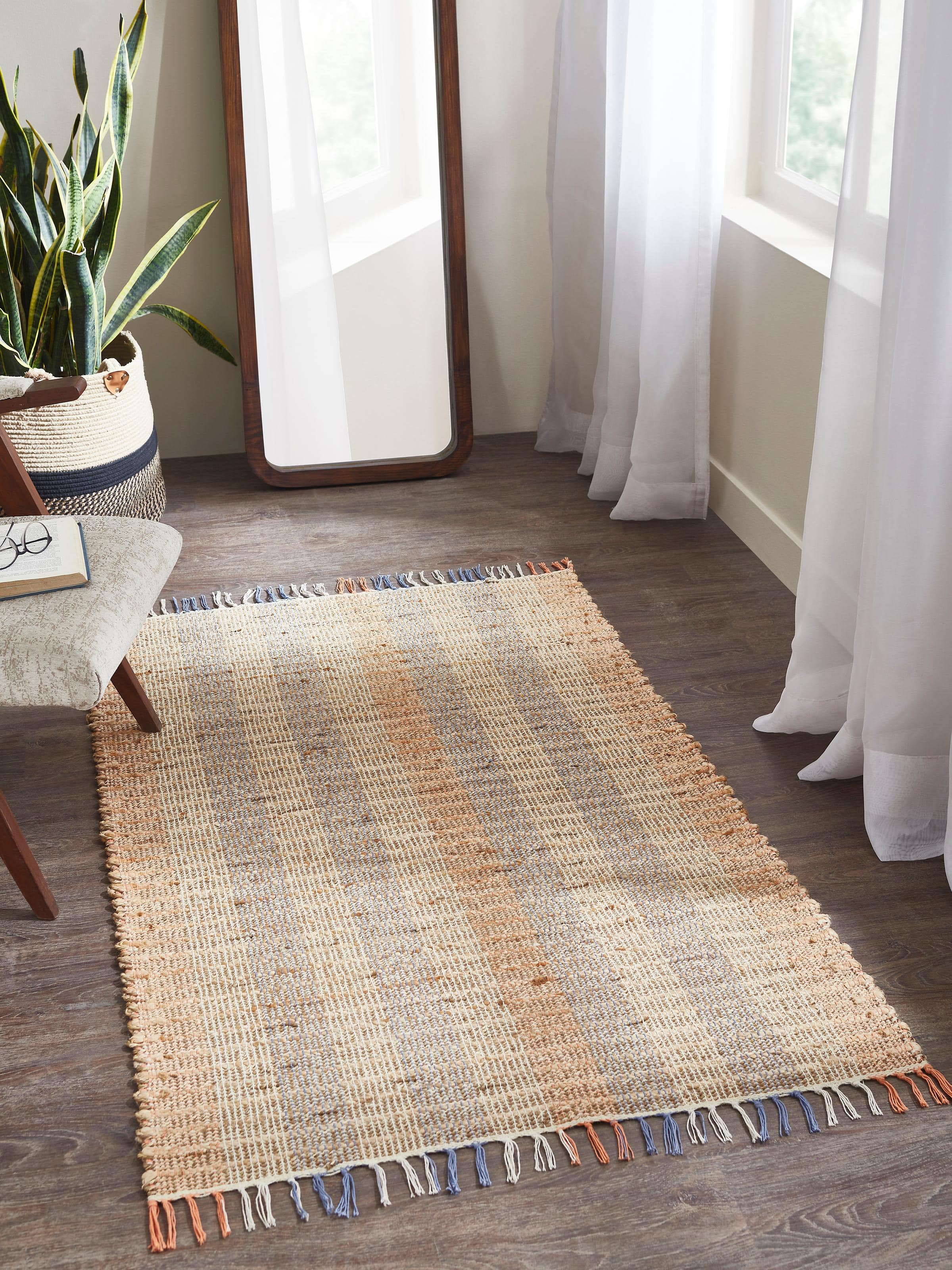 Lifestyle view of beige and blue Lawan natural jute-cotton rug adding texture and warmth to a wooden floor setup