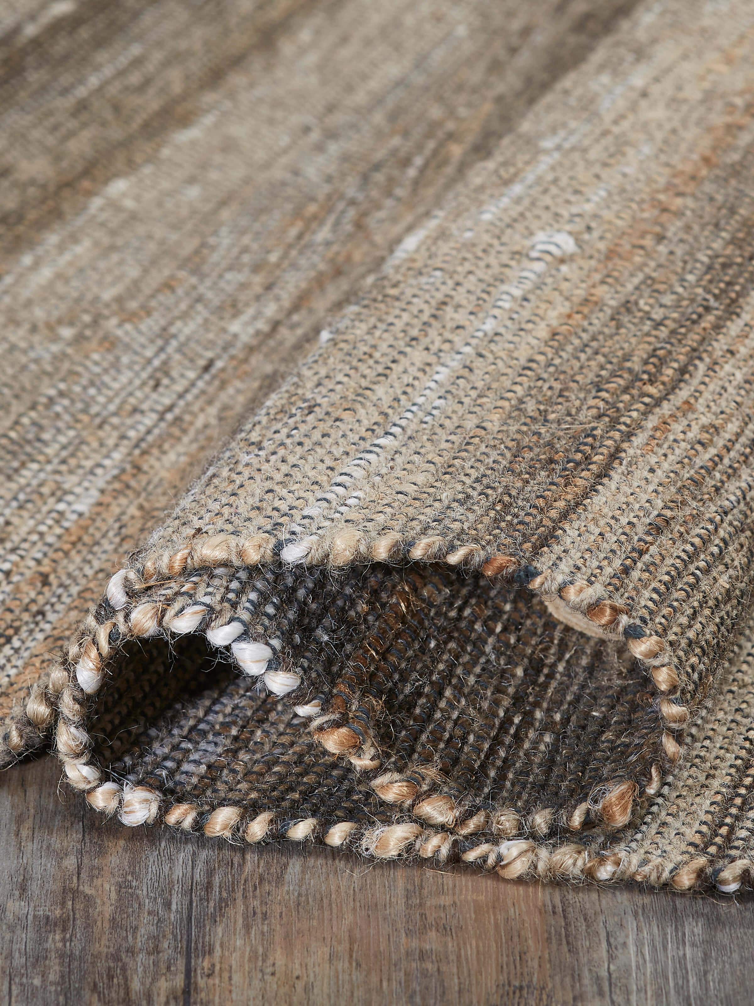 Textured Beige Charcoal Lawan Jute & Cotton Natural Fibre Rug displayed in a room setting, highlighting its versatile use.