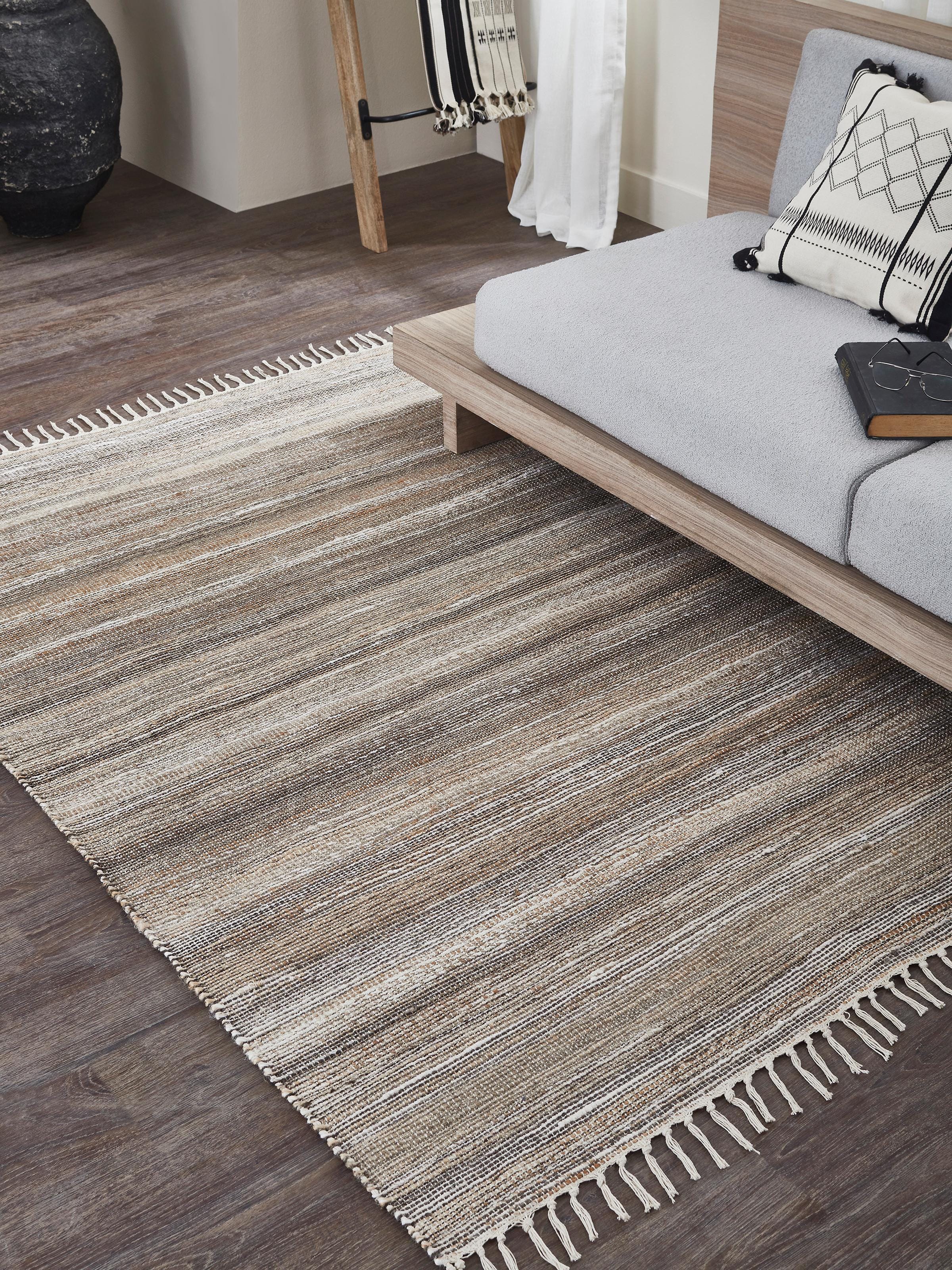 Lifestyle image of Lawan Rug in beige and black tones, showcasing its natural jute and wool texture with subtle geometric pattern.