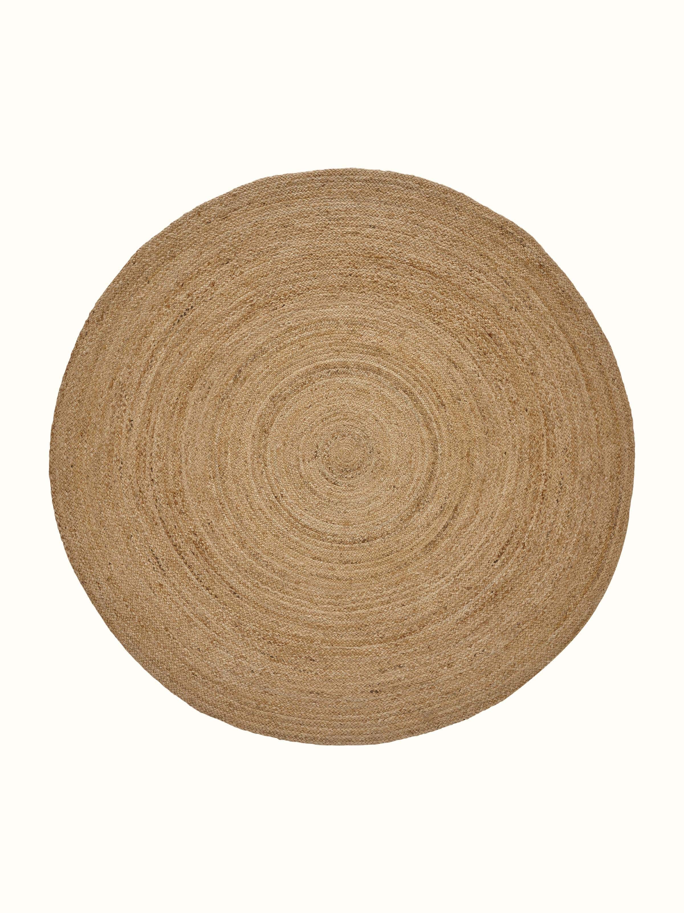 Braided round beige jute natural fibre rug, highlighting its texture and circular design.