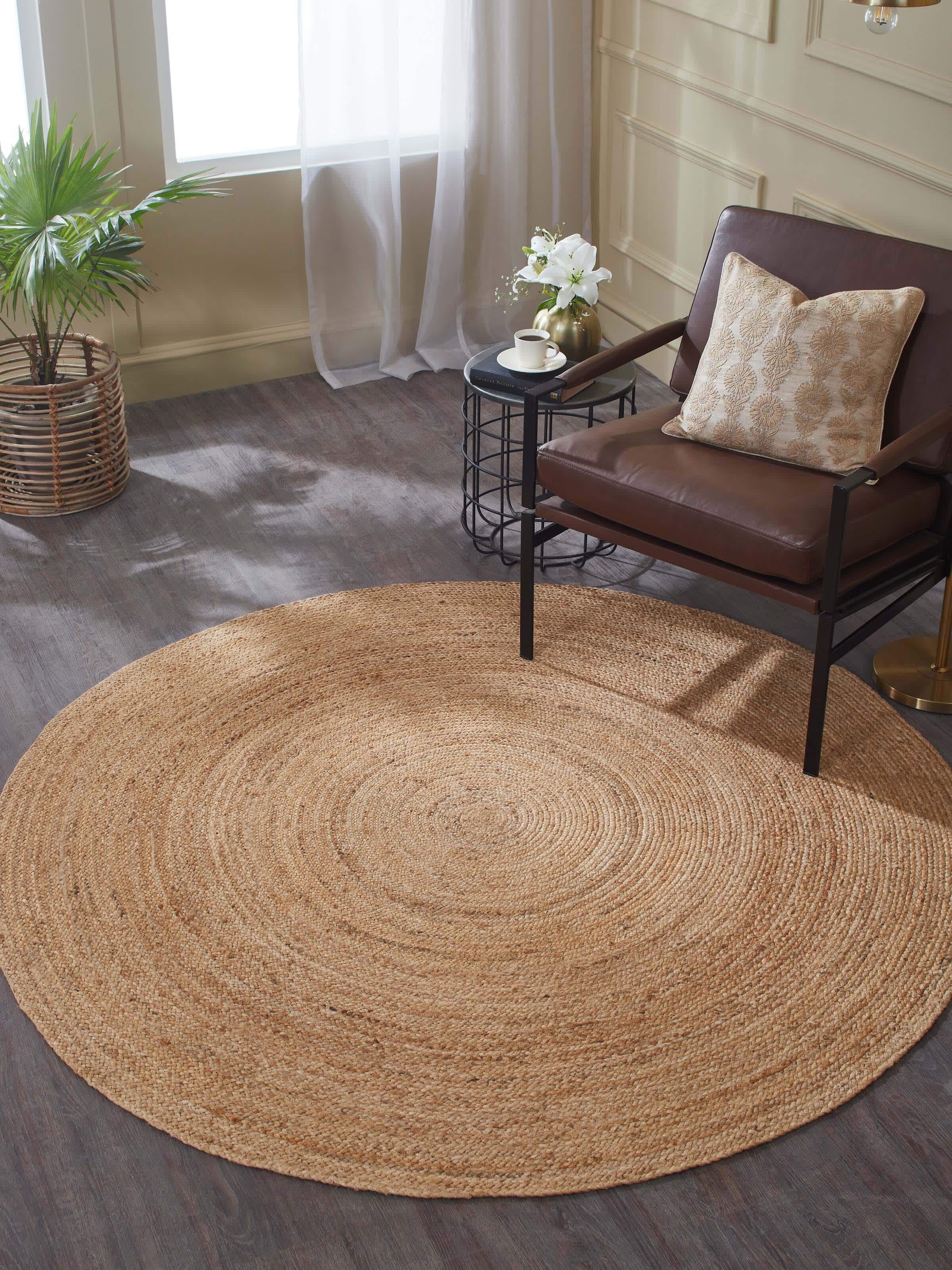 Living space setup with beige round jute rug featuring braided natural fibre texture.