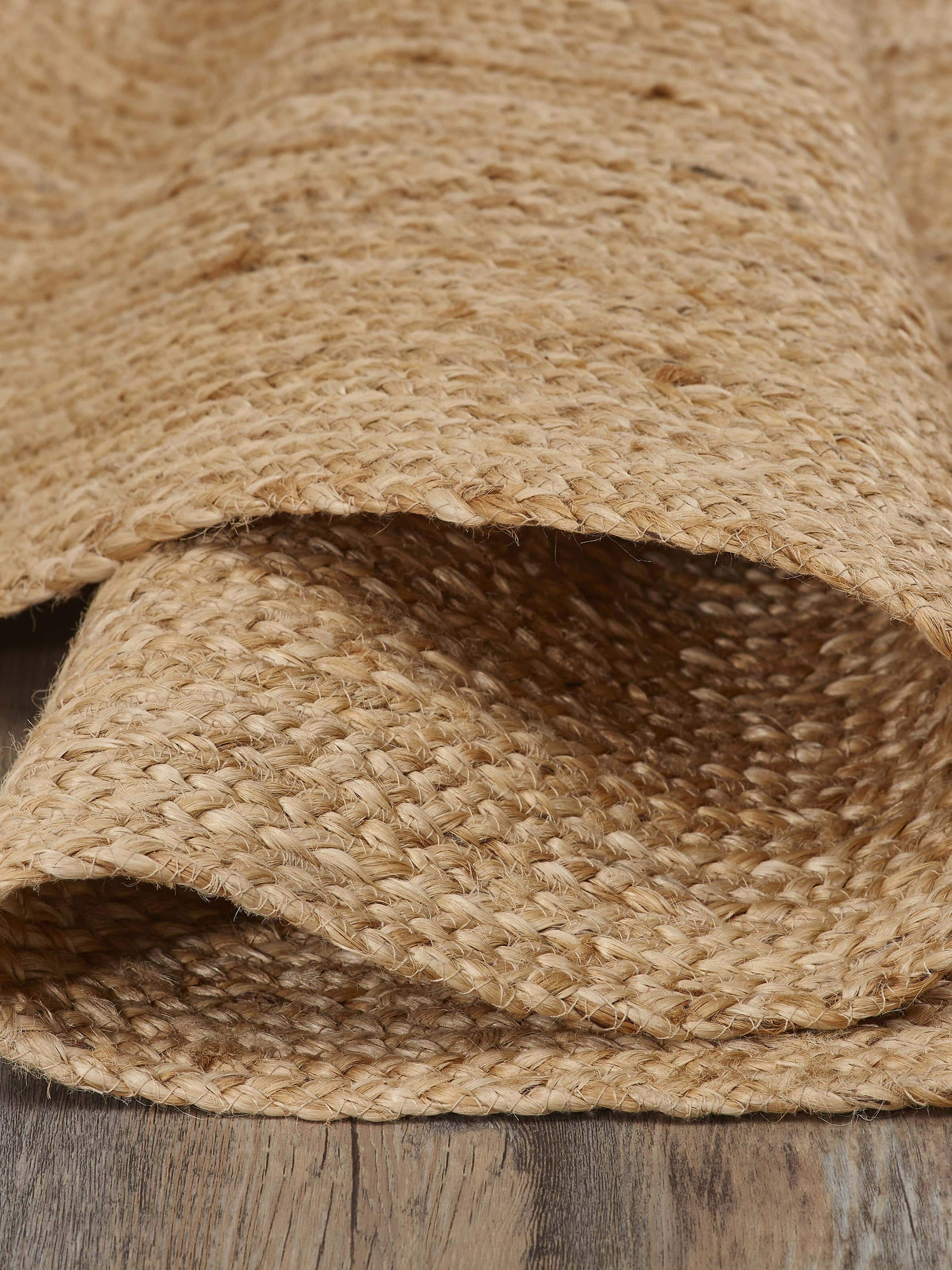 Detailed view of the braided round beige jute natural fibre rug, emphasizing the craftsmanship and material.