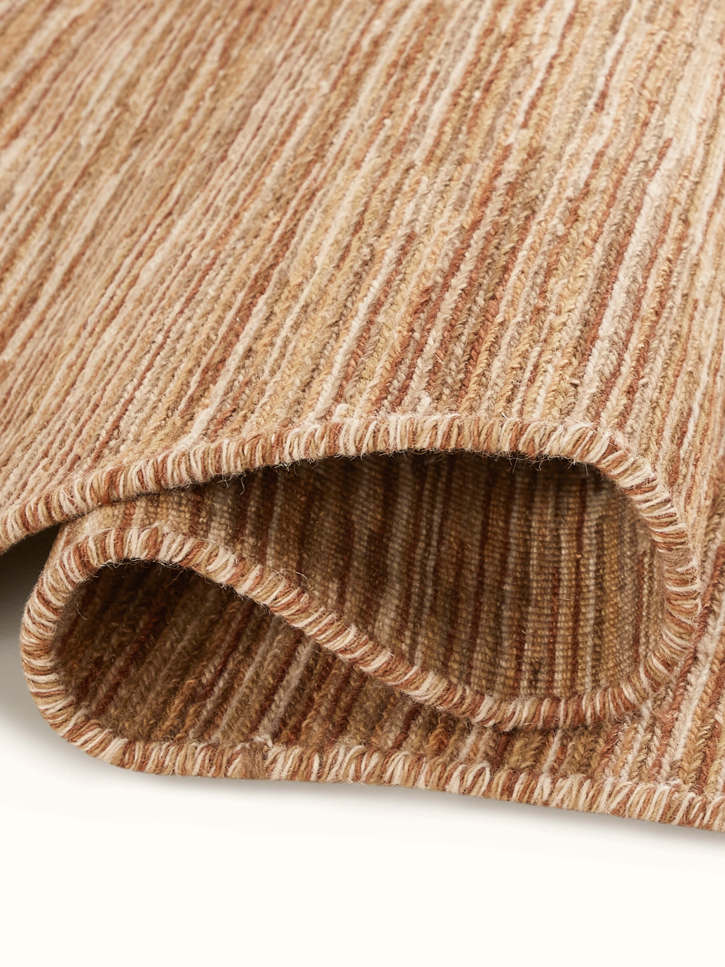 Detailed close-up of the Solid Textured Sumak Beige Rust Bhadohi Wool Hand-Knotted Rug, focusing on the craftsmanship and color.