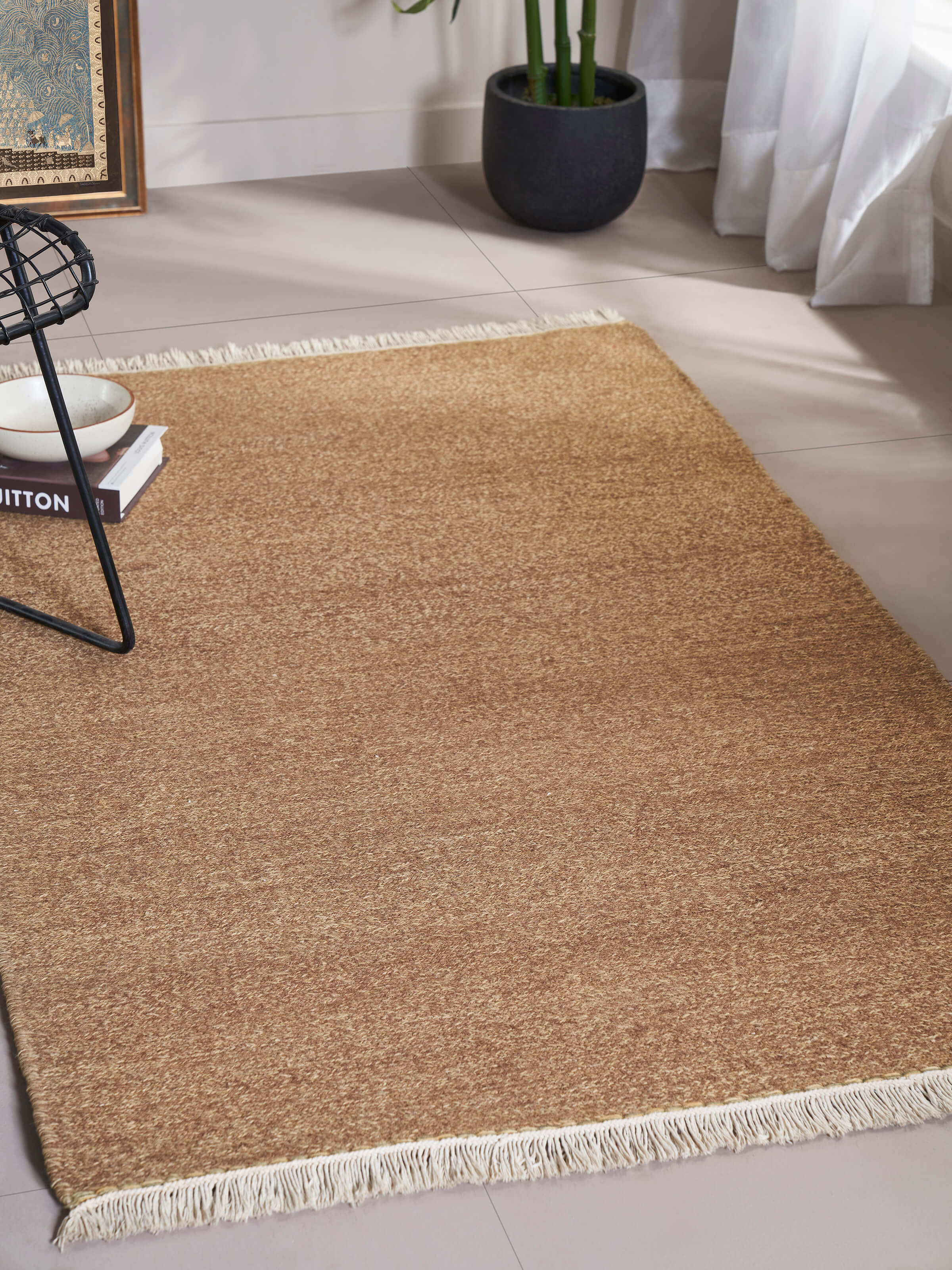 Lifestyle shot of a solid textured sumak brown wool rug, featured in a modern living room setting.
