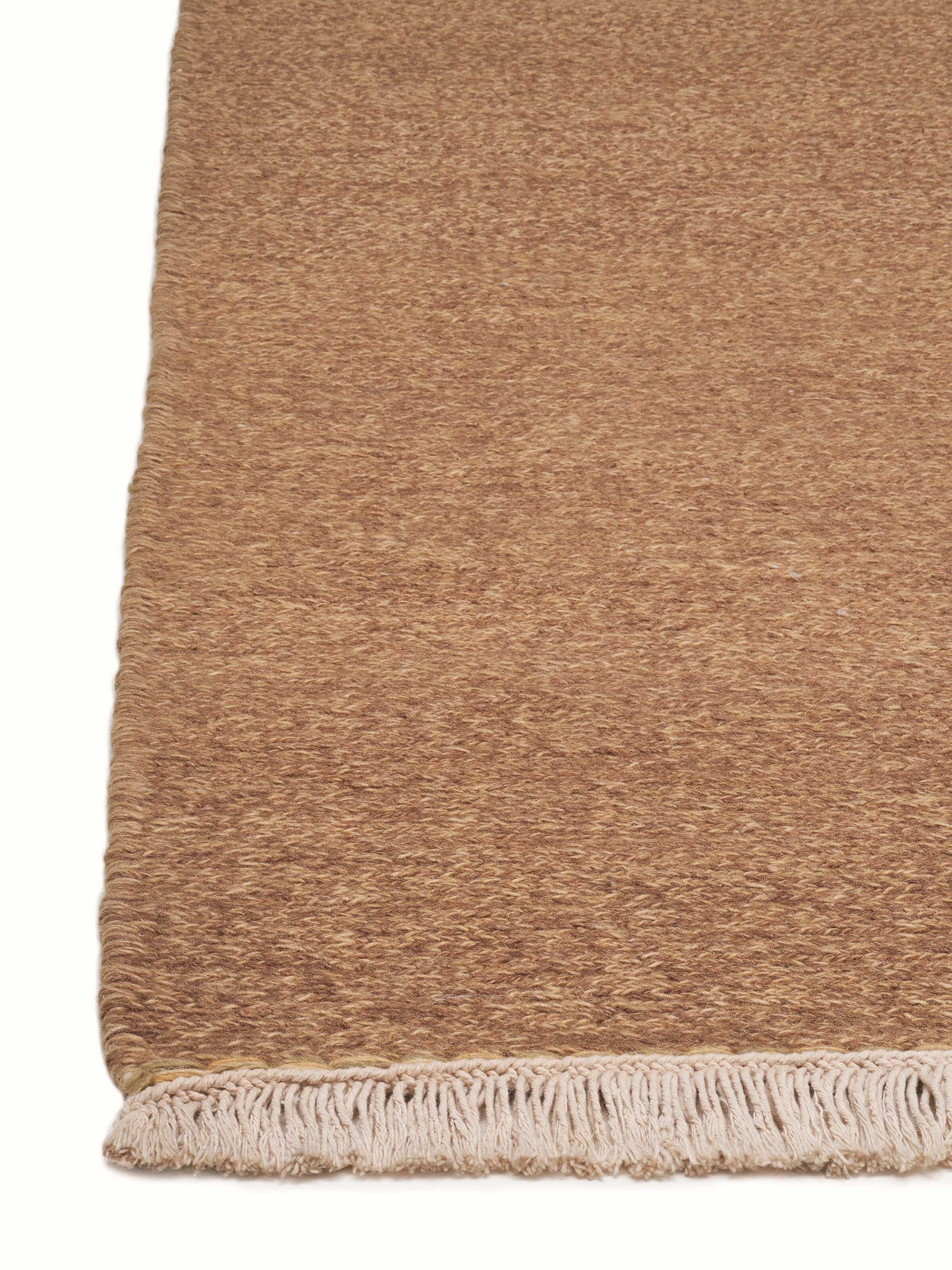 Angled view of a solid textured sumak brown hand-knotted rug, highlighting the detailed weaving and rich color.