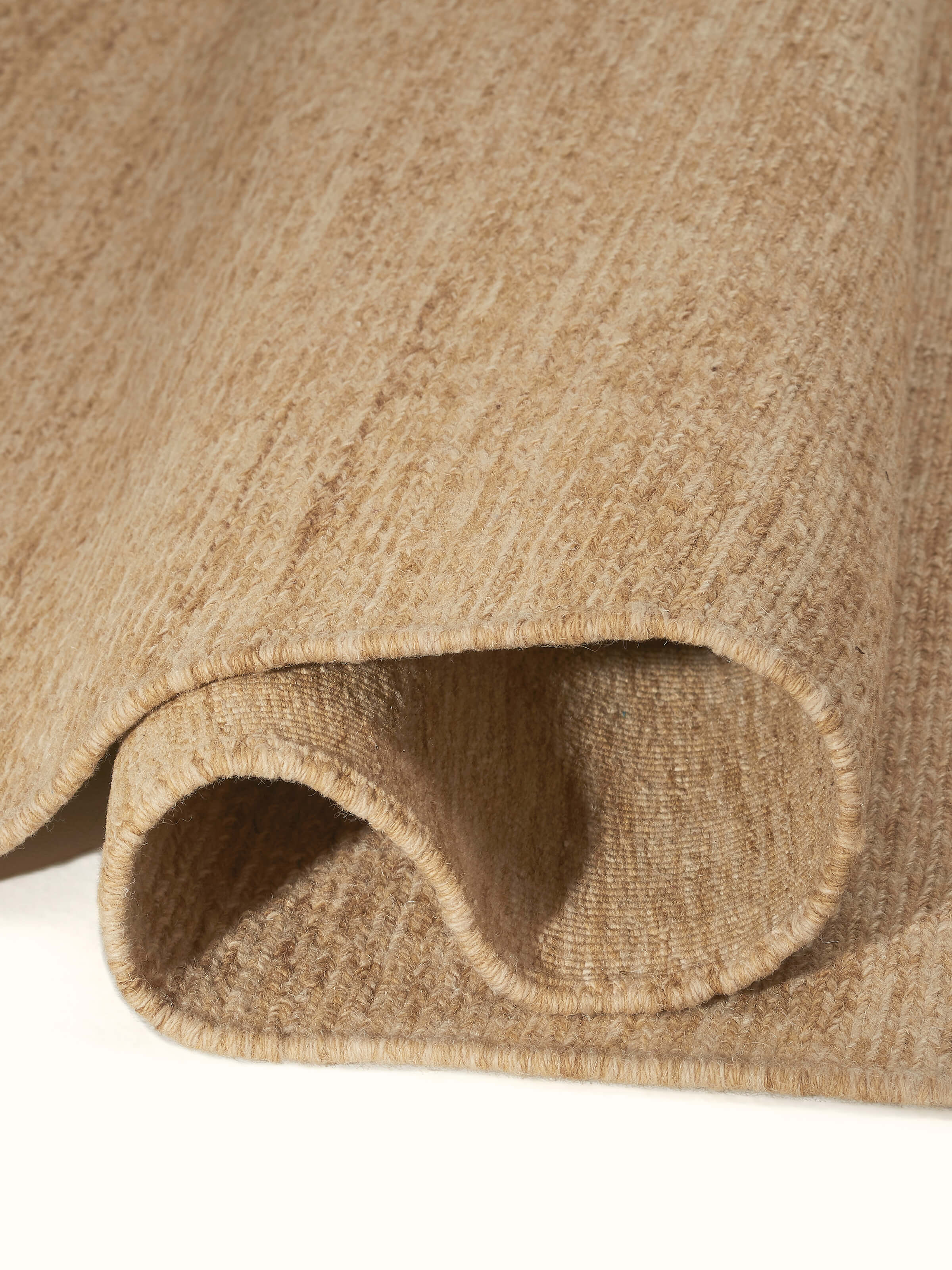 Sumak beige Bhadohi wool hand-knotted rug with a focus on the rug's border detailing and edge design