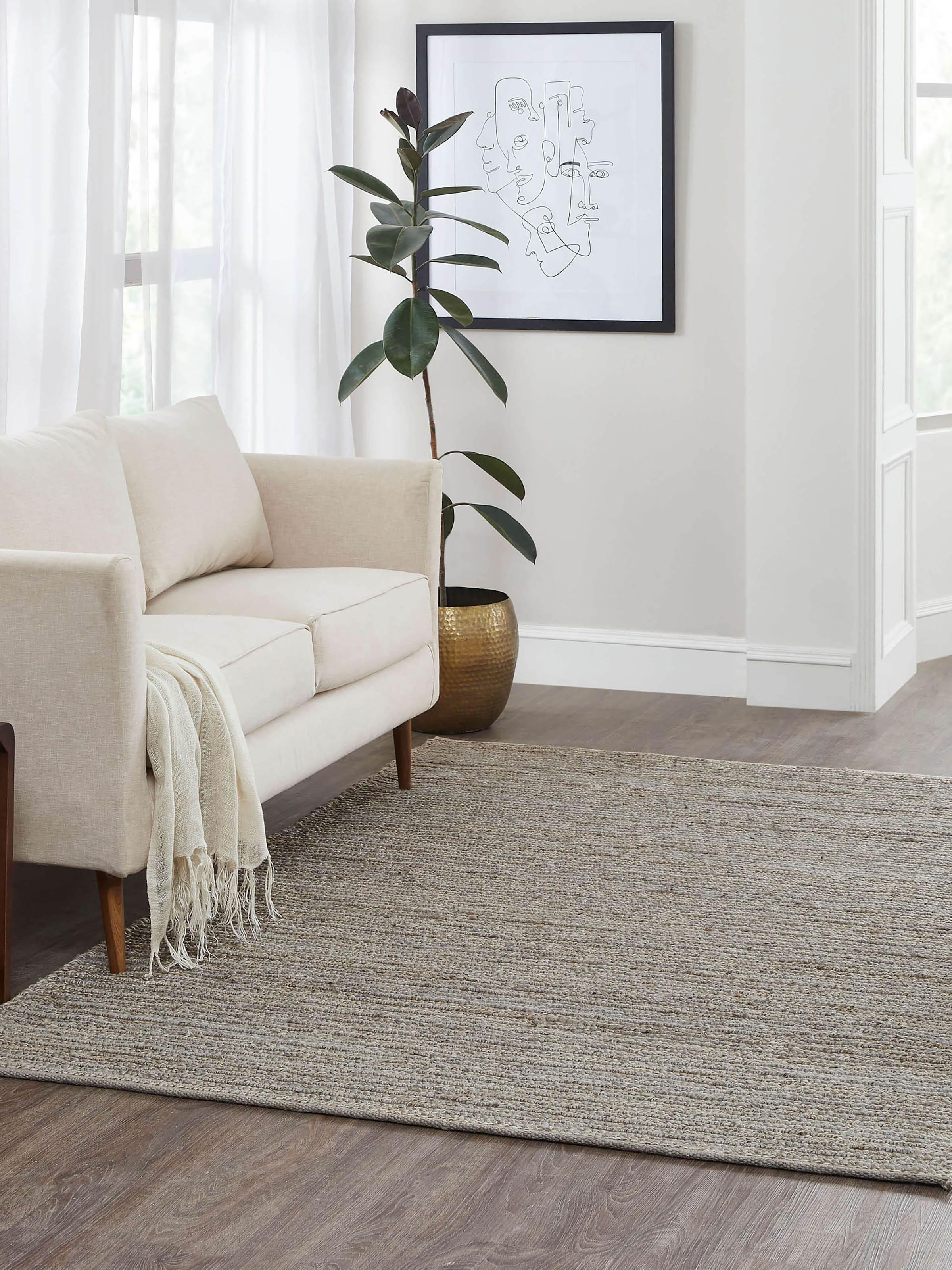 Living room view of large grey jute rug with natural fiber texture and solid minimalist design.