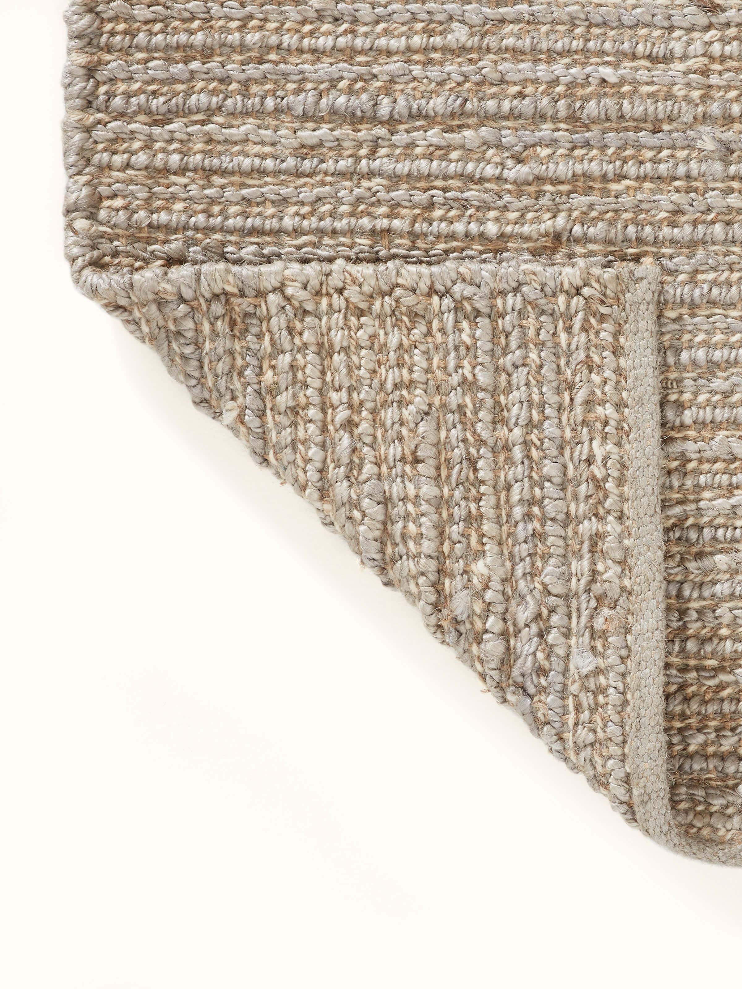 Textured Solid Grey Jute & Wool Rug (5x8 ft) placed on a floor, illustrating its use in a home setting.